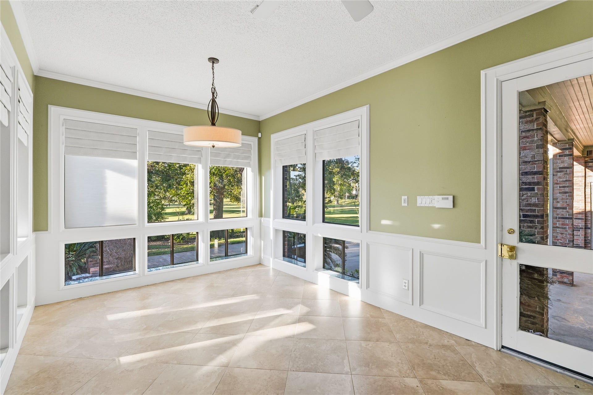 218 Bella Vista Drive, Richmond, TX 77406 Bright and inviting breakfast room with large windows, elegant tile flooring, and a stylish light fixture, perfect for enjoying the scenic outdoor views.