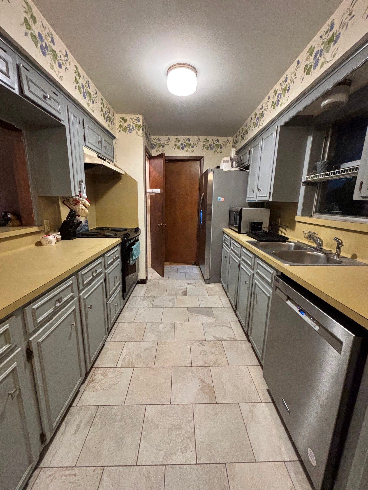 2001 Lamar Drive, Richmond, TX 77469 This exquisite kitchen boasts stainless steel appliances, custom painted cabinets and tile flooring, creating a sophisticated and functional space perfect for entertaining and culinary excellence.