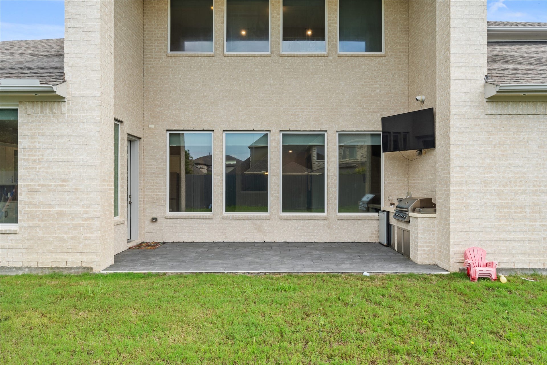 11 Victorian Run, Sugar Land, TX 77498 Covered outdoor patio designed for entertaining, complete with a built-in grill and mounted TV for game-day gatherings. The spacious setup extends the living area outdoors, perfect for relaxing or hosting guests year-round.