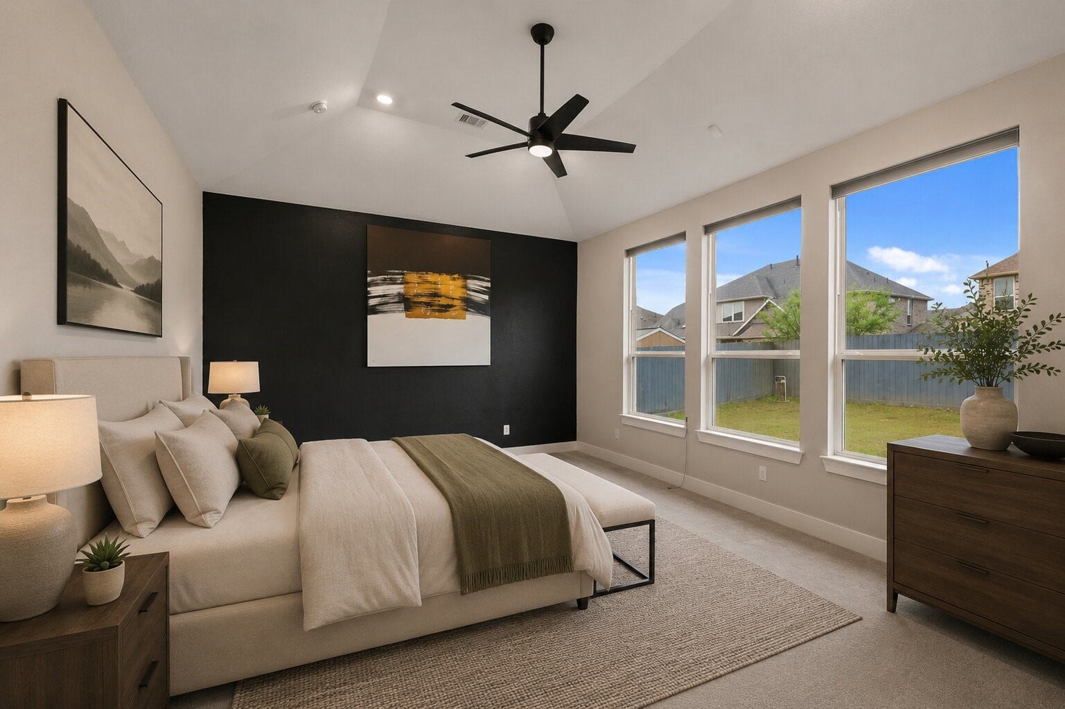 11 Victorian Run, Sugar Land, TX 77498 Spacious primary bedroom featuring a tray ceiling, modern ceiling fan, and a striking accent wall for added character. Large windows line the room, filling the space with natural light and offering relaxing views of the backyard.