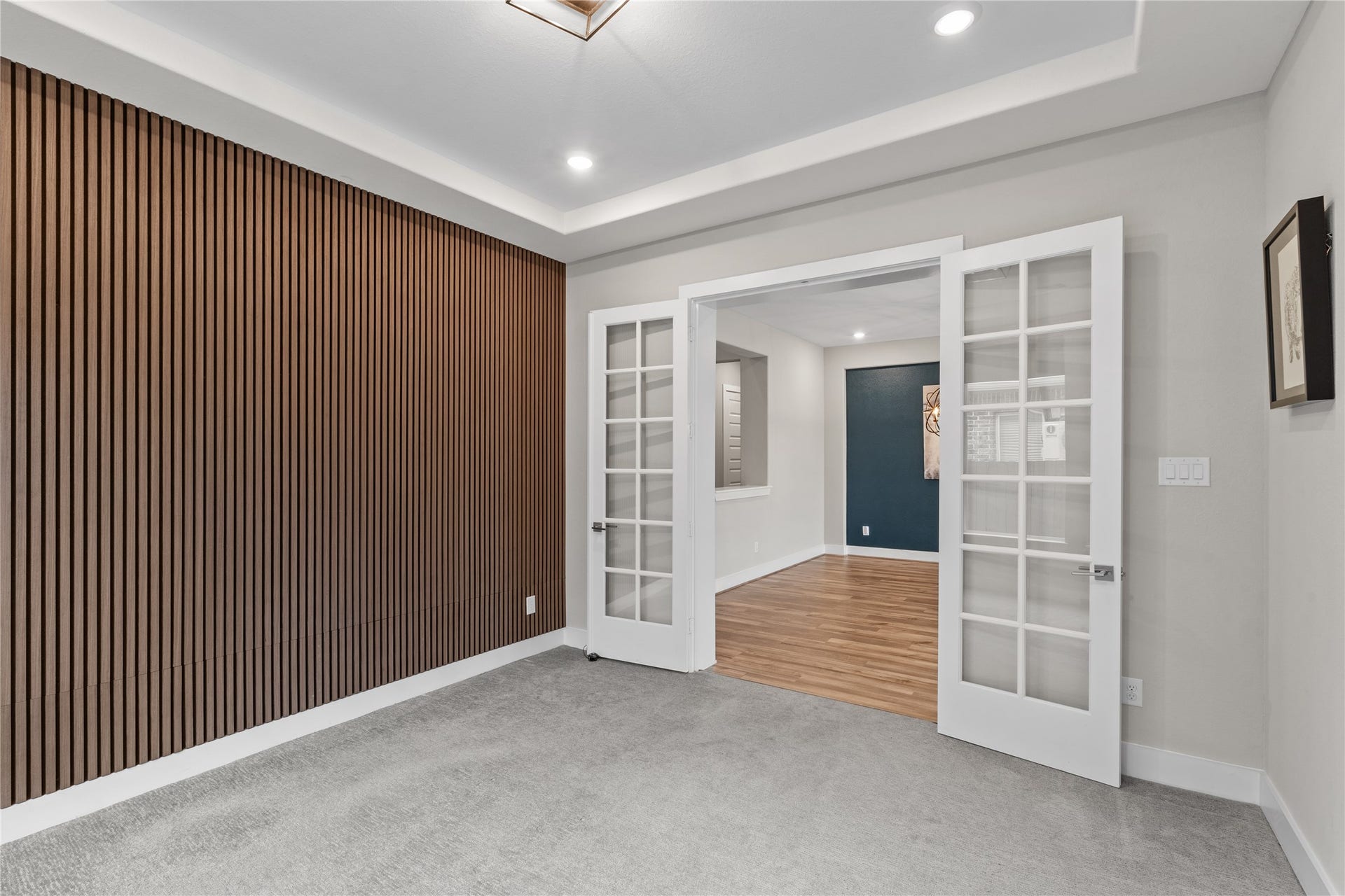 11 Victorian Run, Sugar Land, TX 77498 Stylish flex space with French doors, wood accent wall, tray ceiling, and recessed lightingideal for a home office or study.
