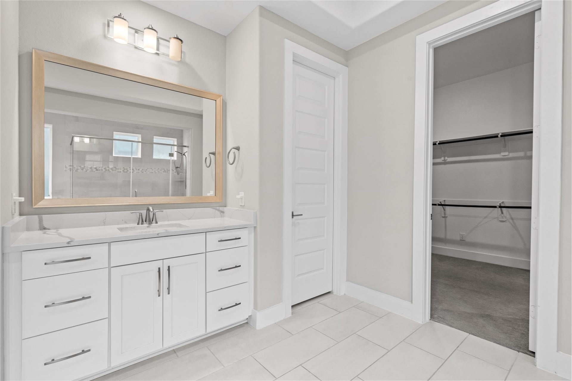 11 Victorian Run, Sugar Land, TX 77498 Well-designed primary bathroom featuring a spacious vanity with quartz countertops, ample drawer storage, and contemporary lighting. Conveniently connected to a large walk-in closet, offering excellent organization and functionality.