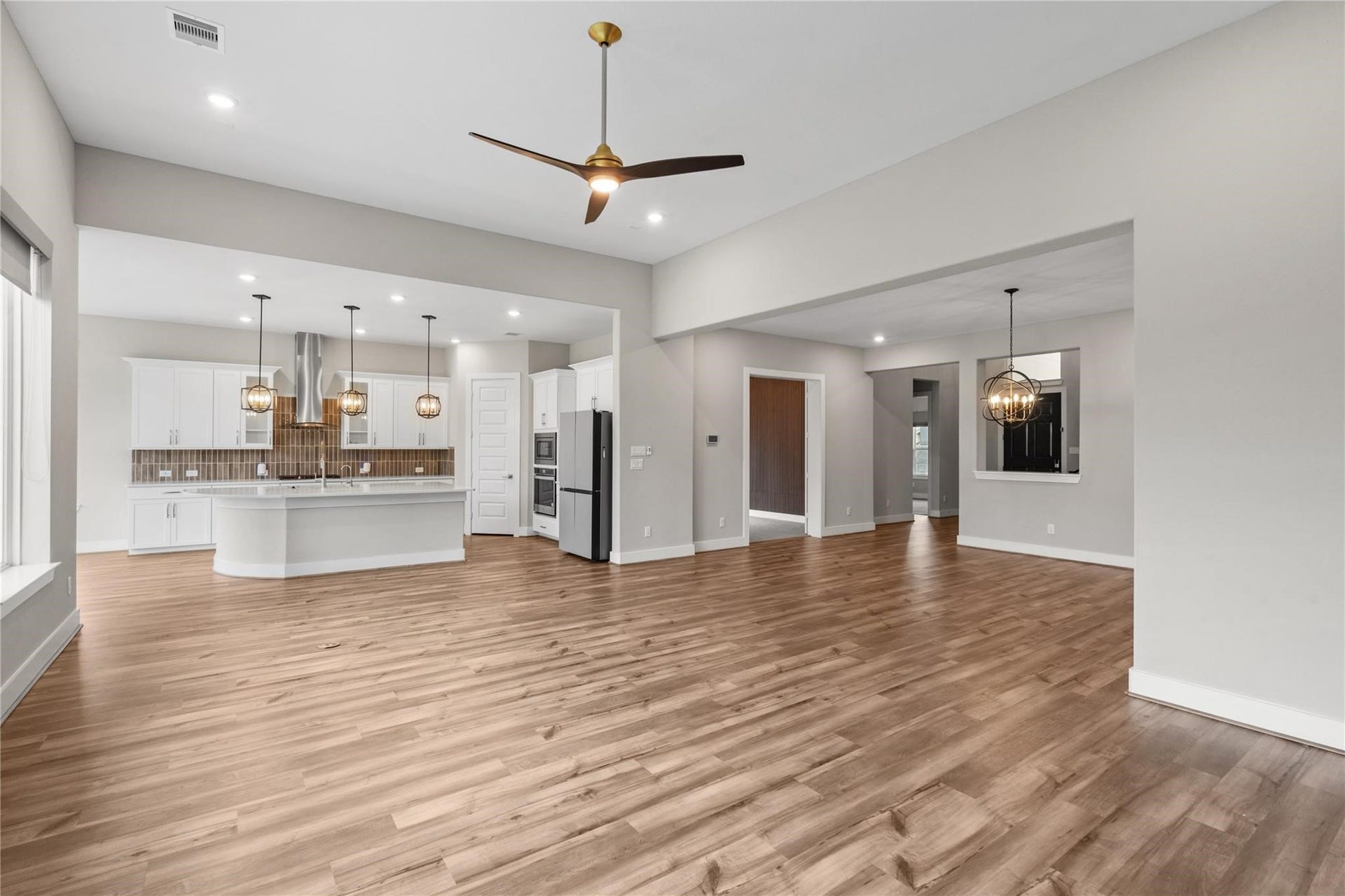 11 Victorian Run, Sugar Land, TX 77498 Open-concept family room overlooking the kitchen, featuring clean modern finishes, recessed lighting, and wide-plank flooring throughout. The spacious layout provides an ideal setting for daily living with easy sightlines to the oversized island and surrounding areas.