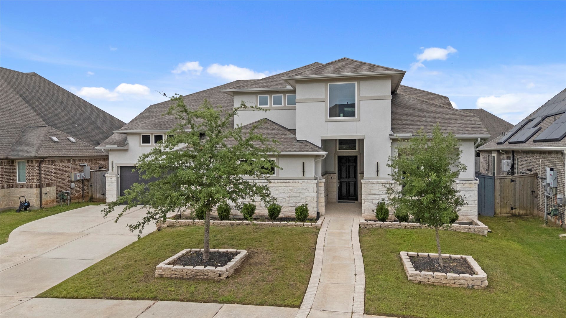 11 Victorian Run, Sugar Land, TX 77498 Modern elegance meets cozy charm in this stunning dream home, framed by clean lines, lush greenery, and bright blue skies.