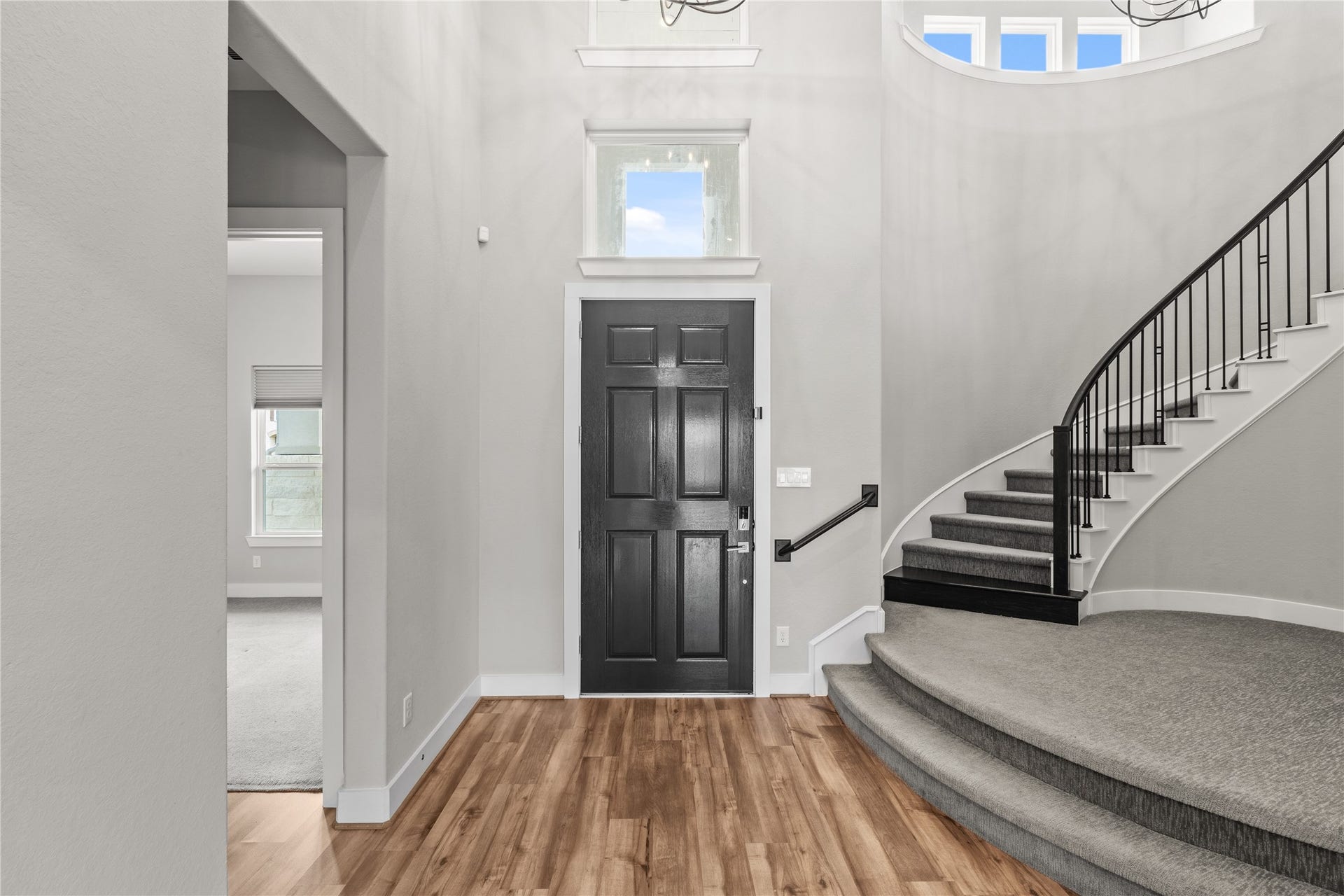 11 Victorian Run, Sugar Land, TX 77498 Welcoming entryway with rich wood flooring, a stylish front door, and an elegant curved staircase, complemented by abundant natural light from the upper windows.