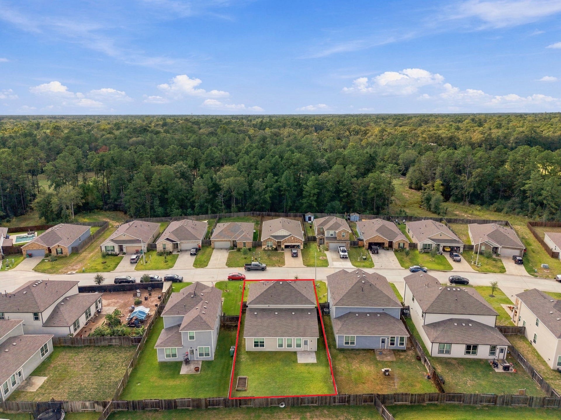 14424 Sunny Bend Way, Conroe, TX 77303 The aerial perspective highlights the mature trees and expansive wooded areas beyond the neighborhood, creating a scenic and inviting setting.