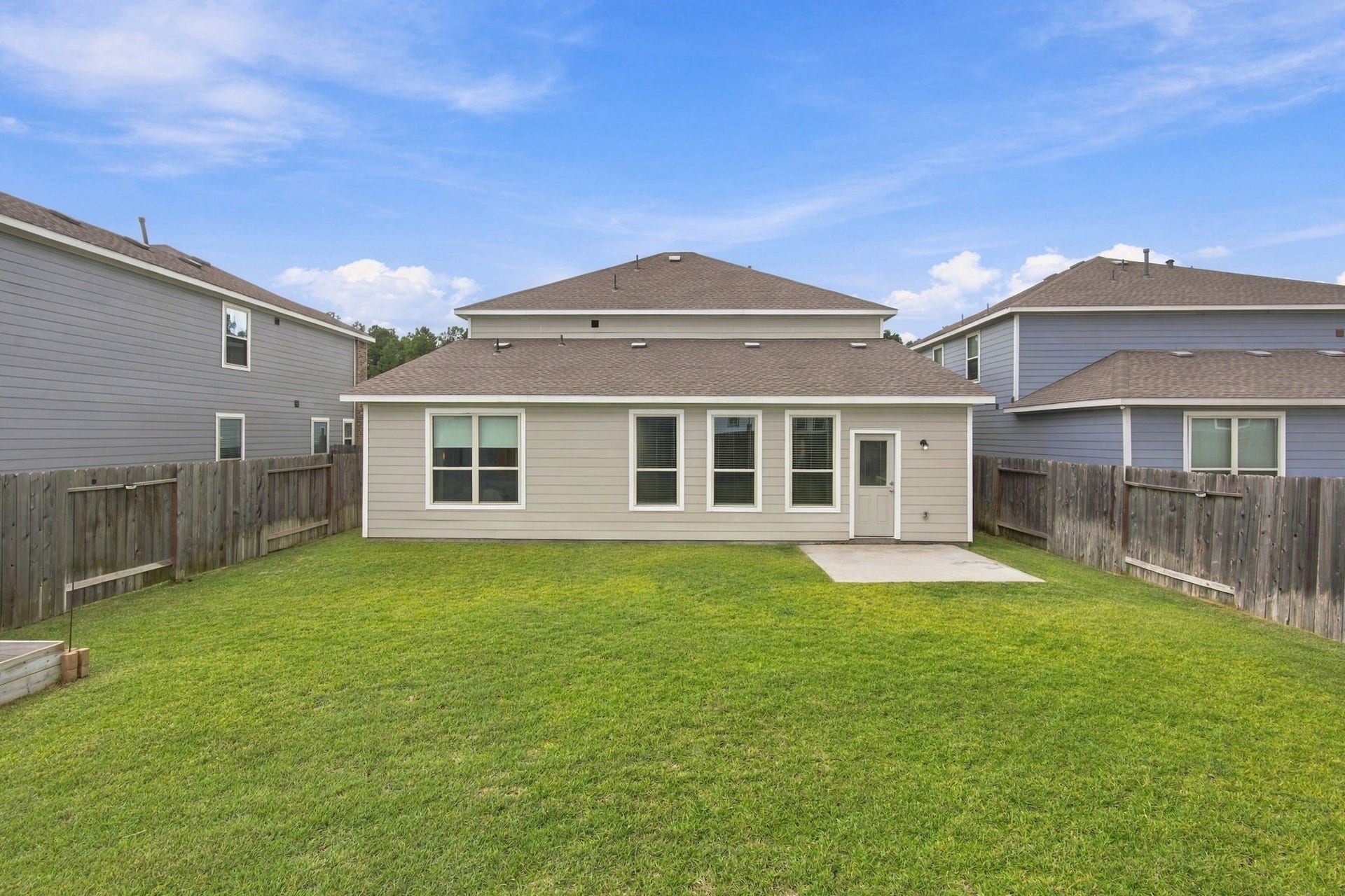 14424 Sunny Bend Way, Conroe, TX 77303 This spacious backyard offers a wide-open green lawn surrounded by a wooden privacy fence, creating an inviting outdoor space with plenty of room for recreation, relaxation, and entertaining.