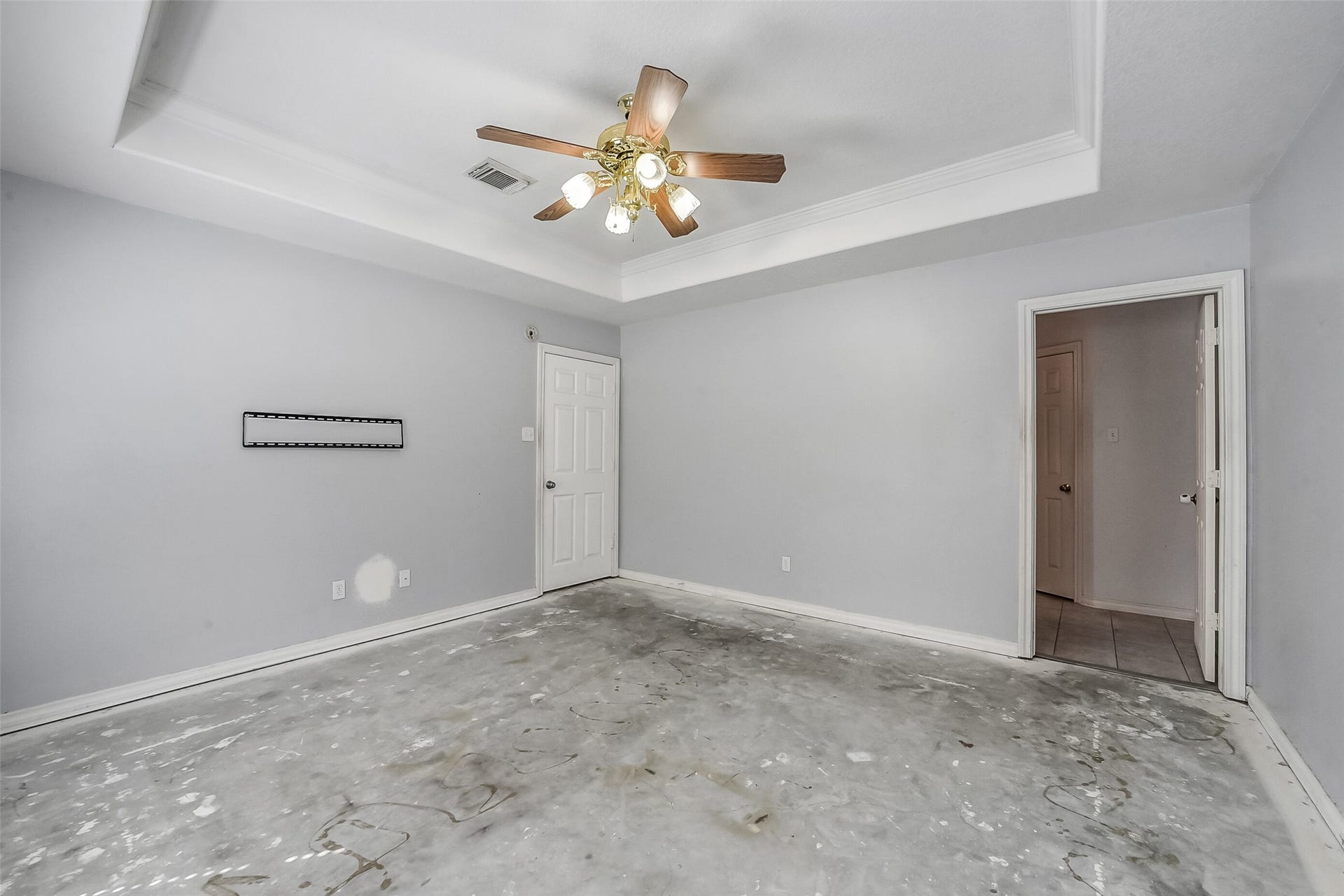 22911 Keith Drive, New Caney, TX 77357 The spacious primary bedroom offers a peaceful retreat with a tray ceiling, crown molding, and a ceiling fan. This room is waiting for your choice of flooring.