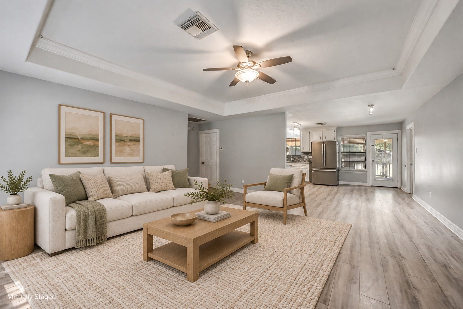 22911 Keith Drive, New Caney, TX 77357 This inviting family room features a tray ceiling accented with crown molding, a ceiling fan, and abundant natural light. This photo is virtually staged.