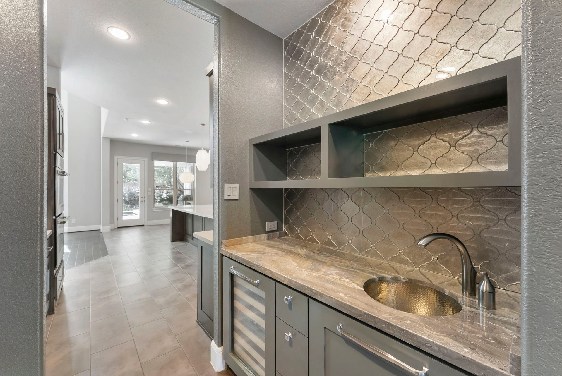 Custom wet bar featuring sleek cabinetry, a prep sink, and a built-in wine fridge.
