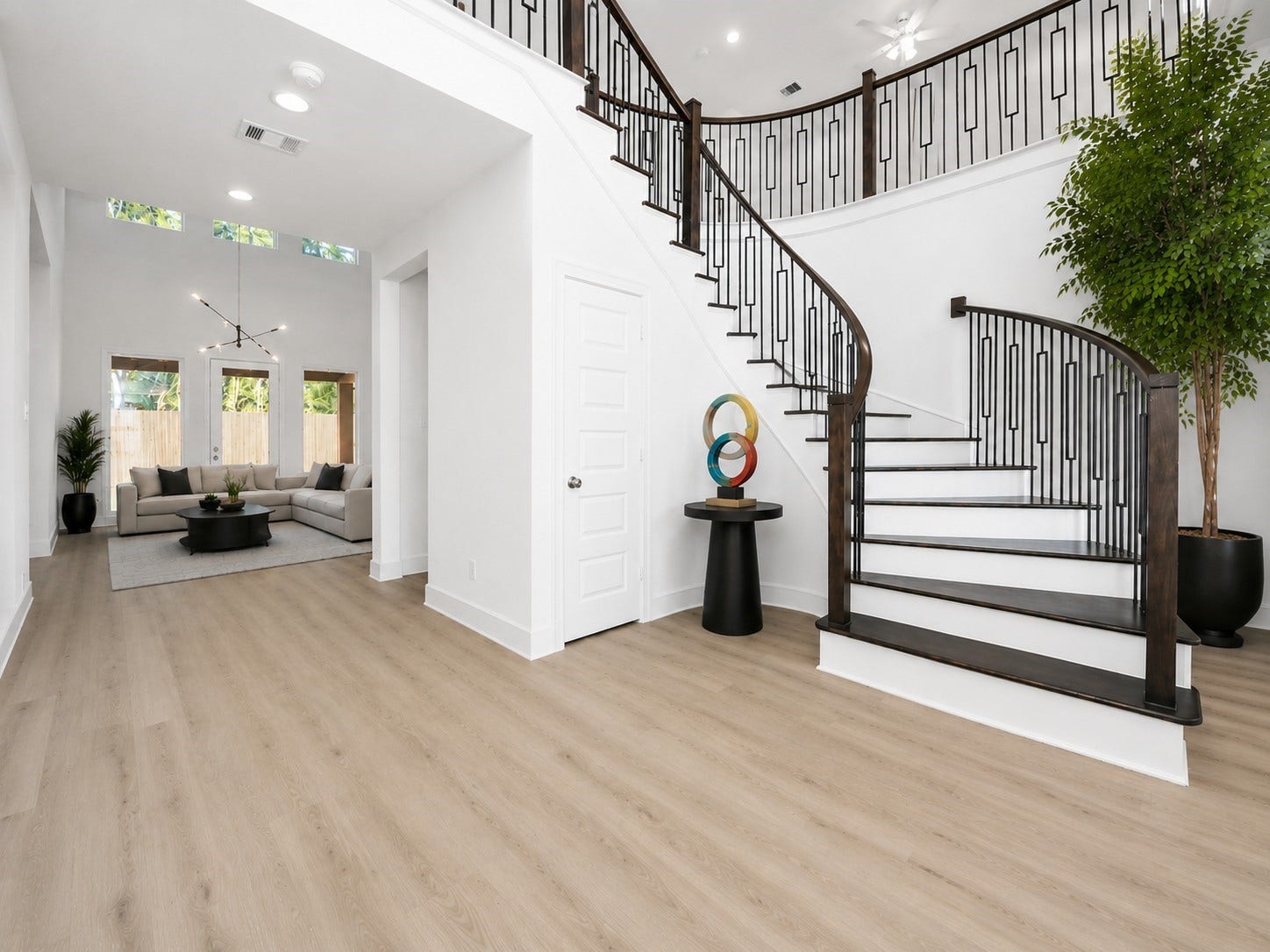 205 Wyndemere Drive, Montgomery, TX 77356 Grand formal entryway w/sweeping staircase w/real wood treads and contemporary spindles. Virtually staged floor plants and furniture and contemporary light fixture in ivingroom.