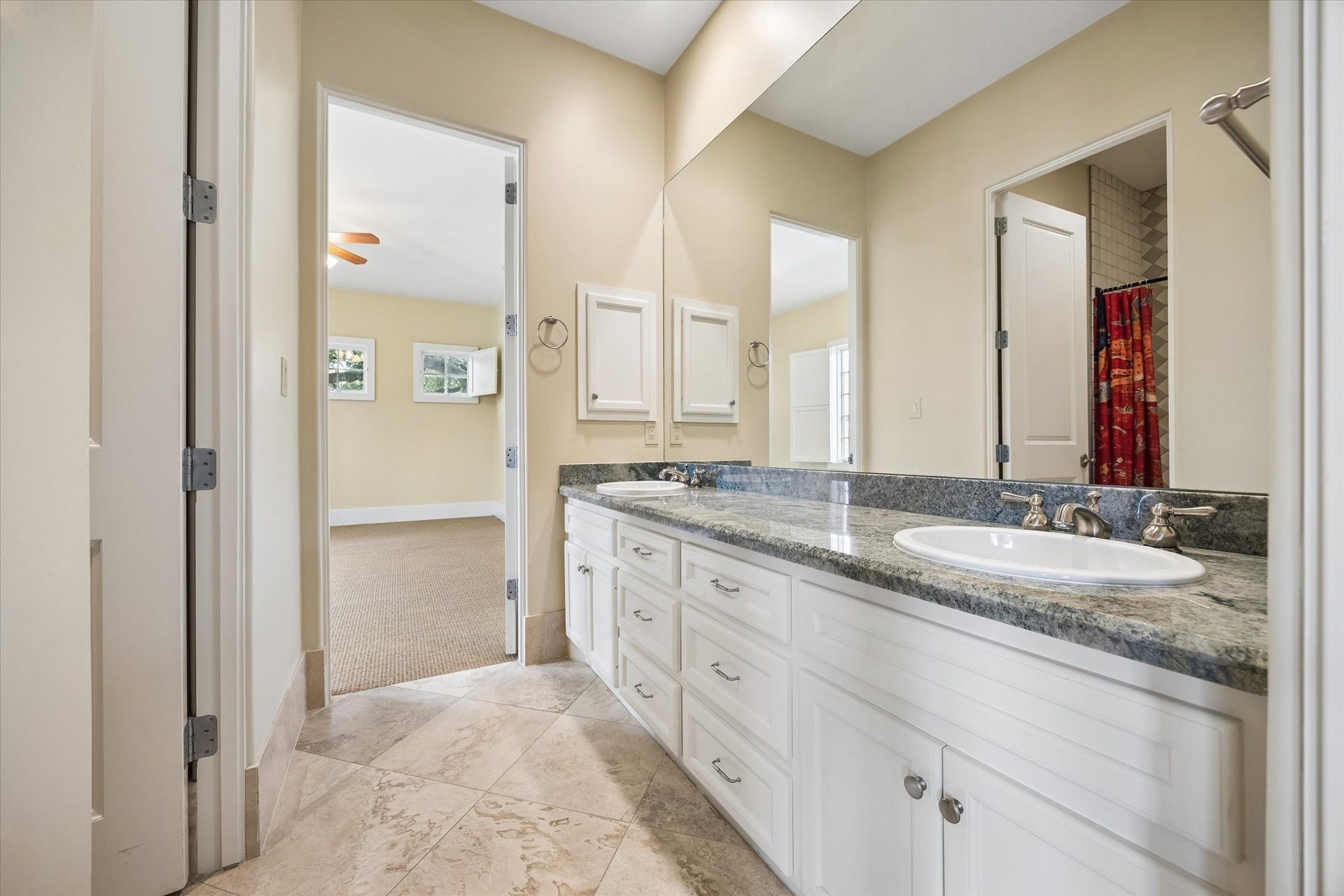 5120 Mt Vernon, Houston, TX 77006 A Hollywood bath connects the secondary bedrooms. Note the limestone tile and granite countertops. Through the door to the left is the shower/bath and toilet.