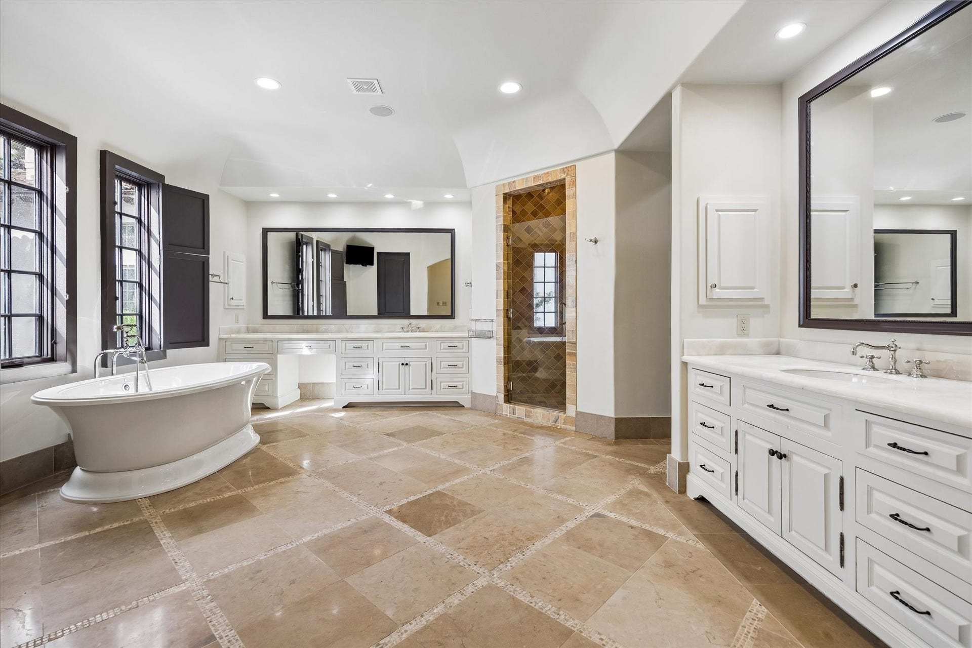 5120 Mt Vernon, Houston, TX 77006 The primary bath with custom limestone floors, standing tub and dual vanities. The closet is to the right of the walk-in shower.
