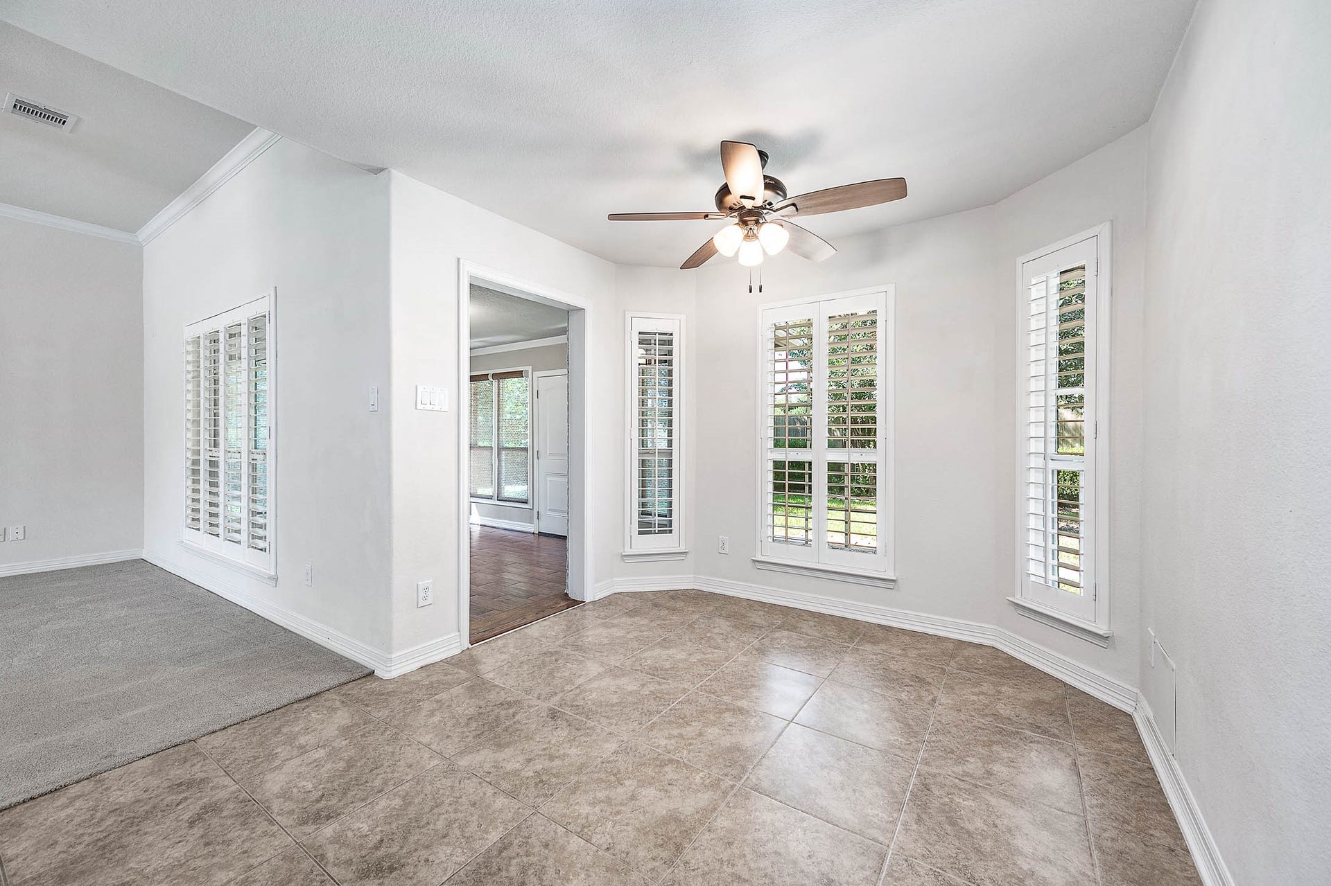 Enjoy your morning coffee in a bright breakfast area with stunning backyard views, highlighted by elegant windows and a cozy atmosphere.