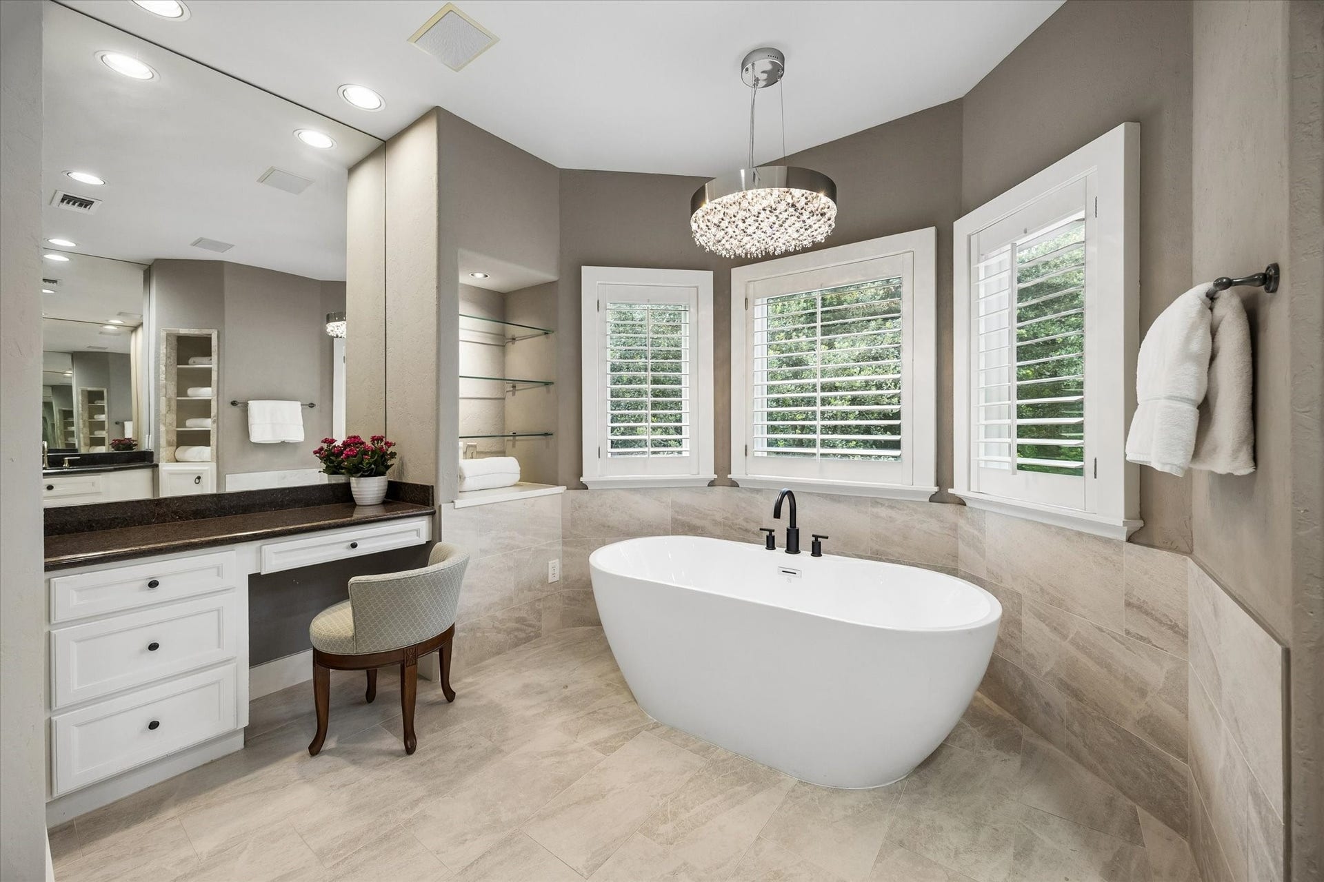 Updated spa-like primary bath with freestanding tub, vanity area and bay window.