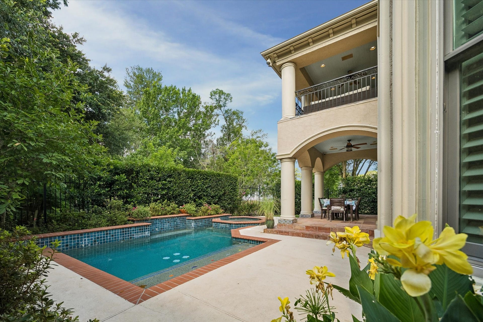 Sparkling pool and spa with vibrant, lush setting.