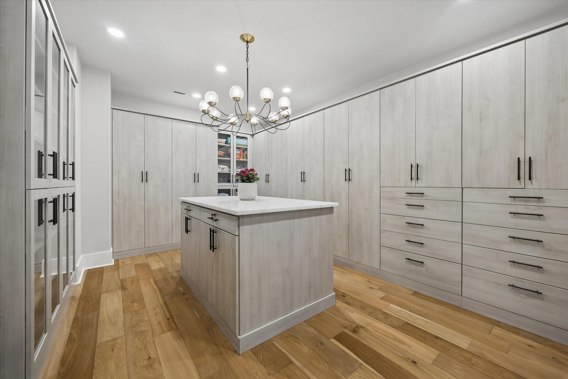Custom fitted primary closet with built-in island storage.