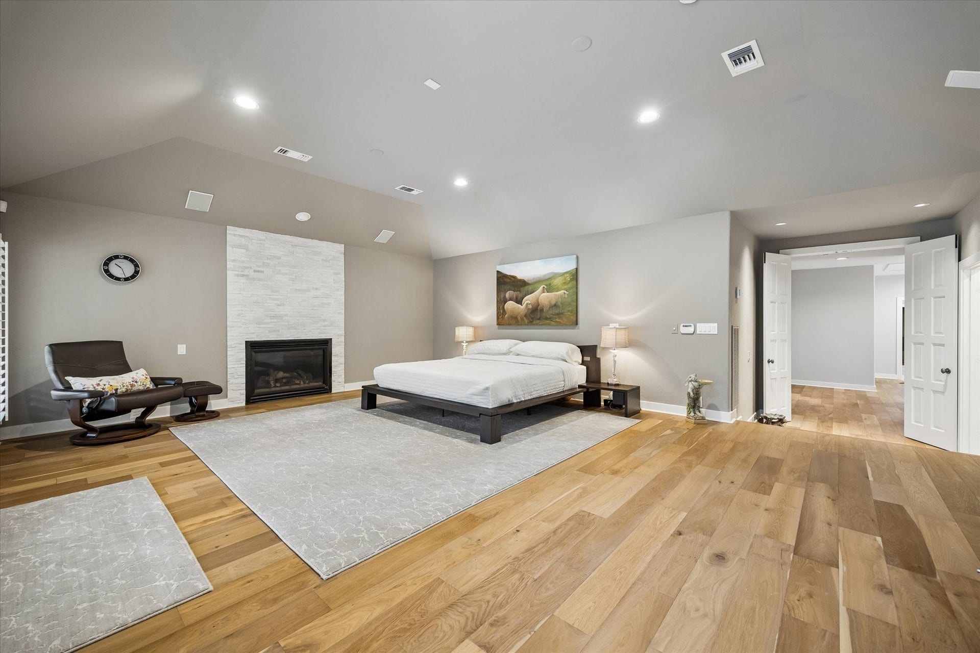 Upstairs primary suite offers hardwood floors, vaulted ceiling, fireplace and huge footprint.