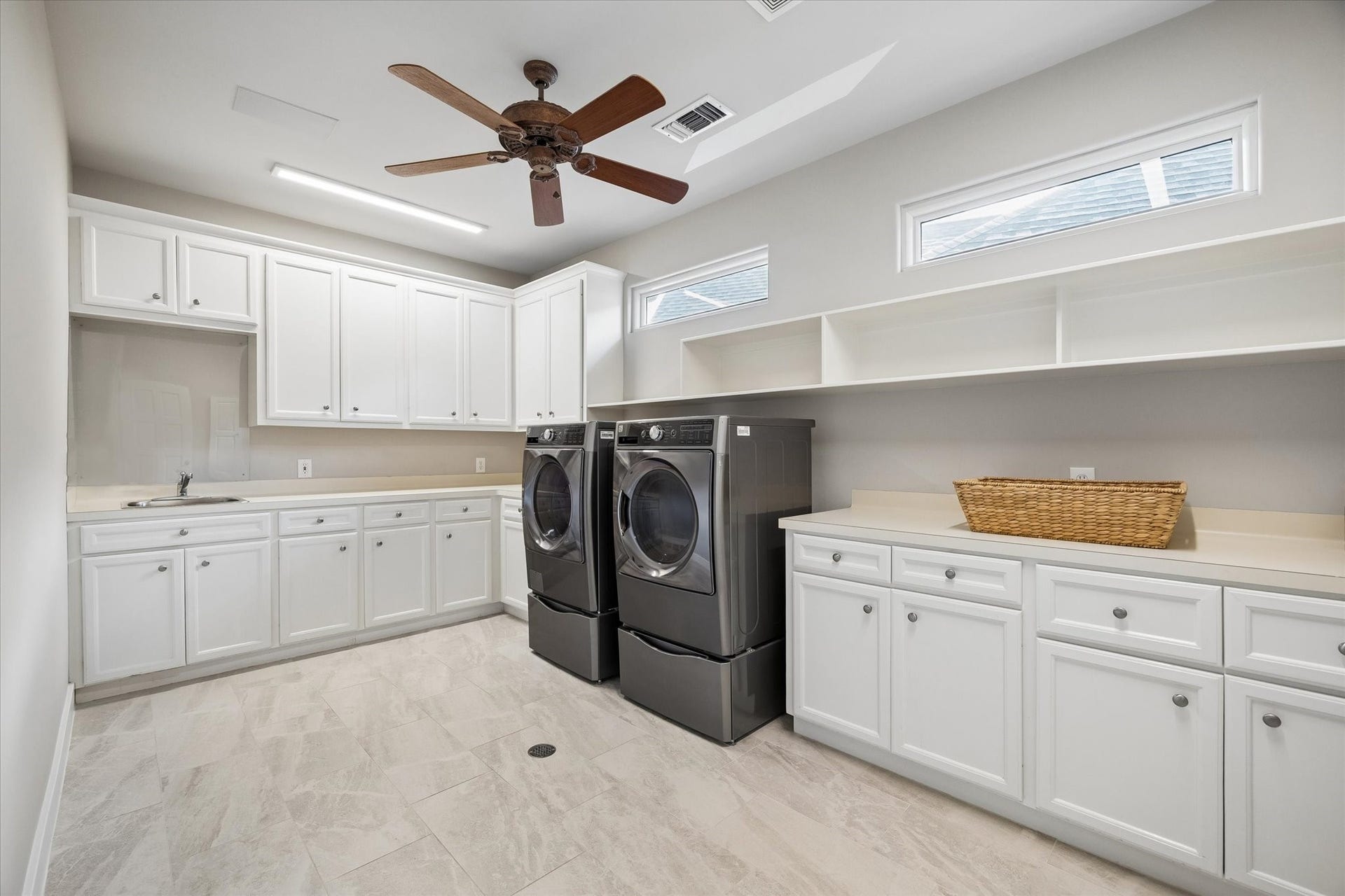 Huge utility room with ample storage, side by side front loading washer and dryer.