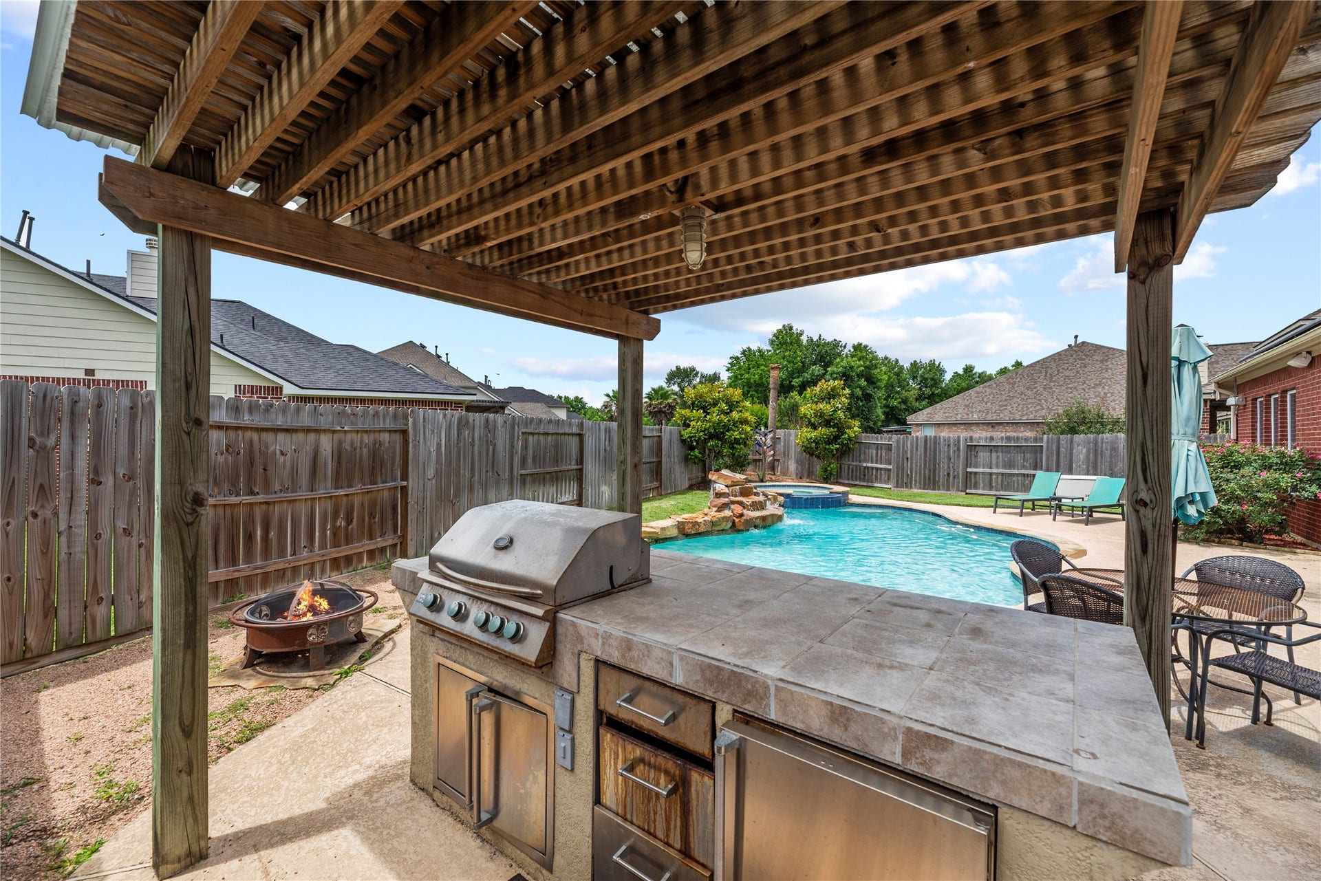 3707 Cat Springs Lane, Missouri City, TX 77459 Hosted under a rustic pergola, this professional outdoor kitchen features a high-end grill and plenty of counter space for poolside dining.