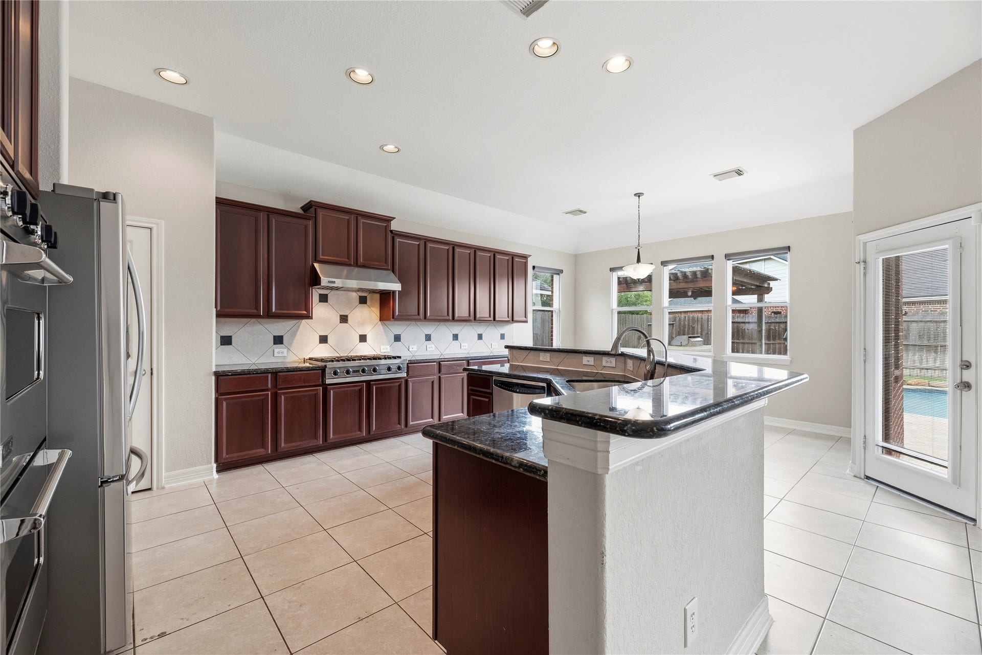 3707 Cat Springs Lane, Missouri City, TX 77459 Overlooking the family room, this luxury kitchen serves as a central hub for the home, combining traditional style with modern high-end convenience.