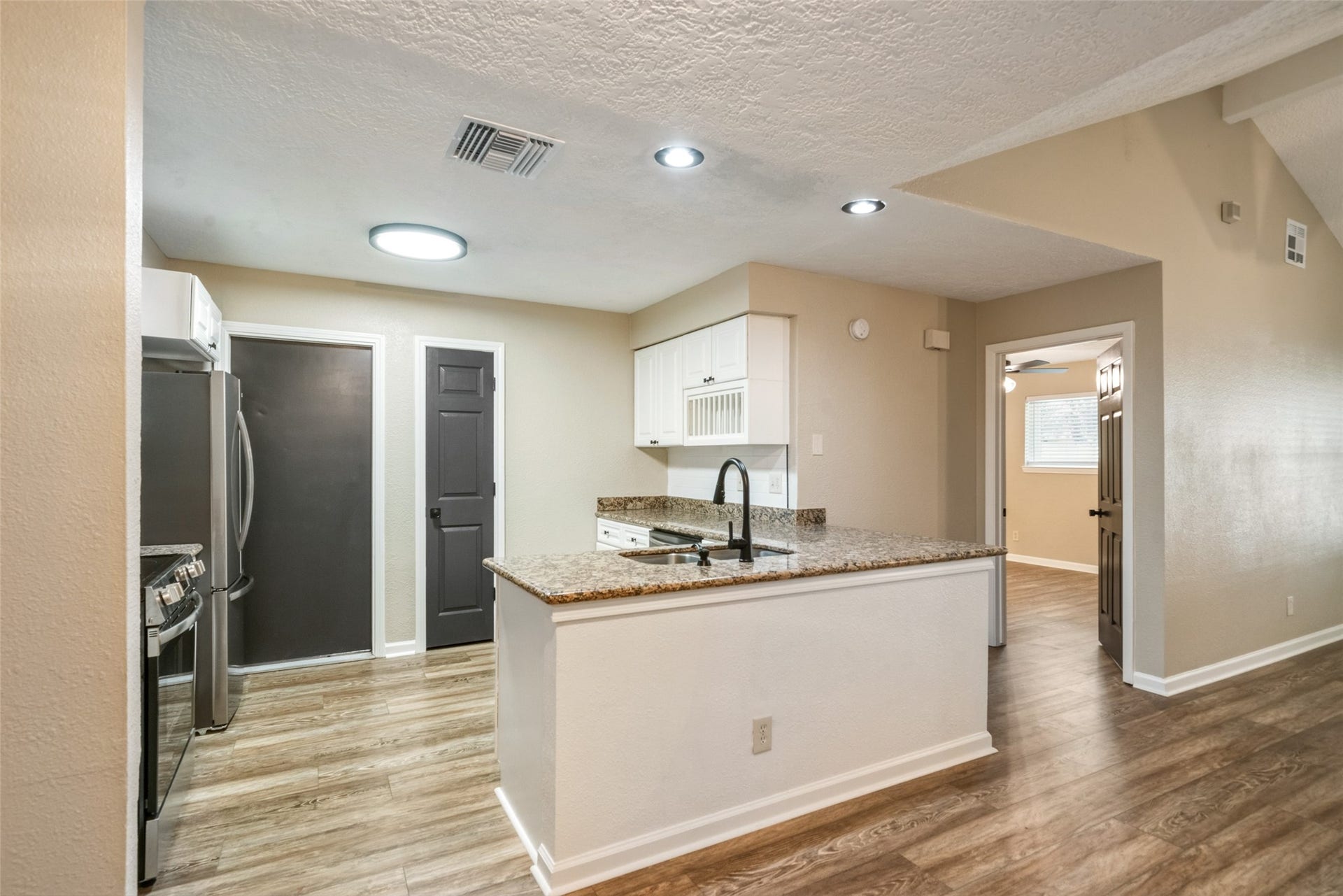 3200 Sand Reef Lane, League City, TX 77573 Kitchen, with new stainless steel appliances, is open to dining and living areas.