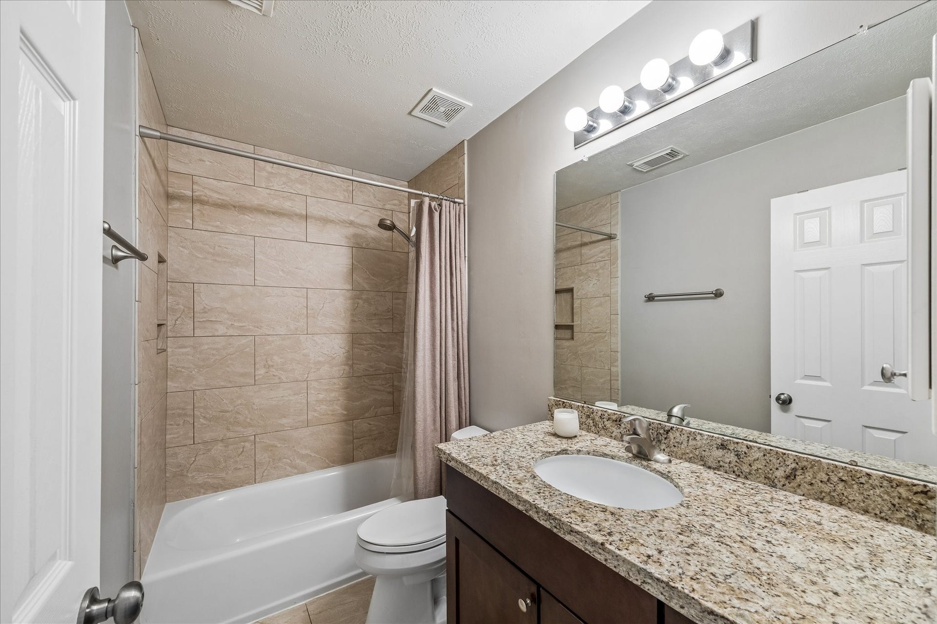 Charming secondary bedroom with vaulted ceilings and warm hardwood floors.