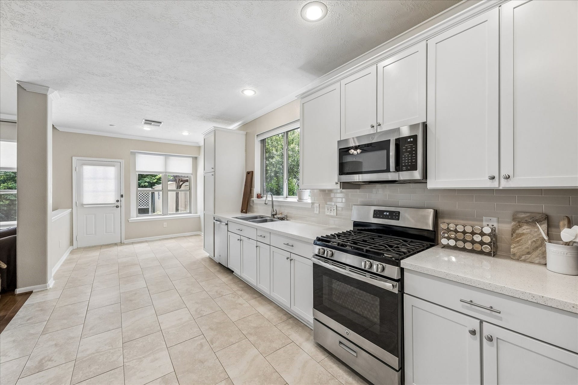 Alternate view of the kitchen showing entry into dining room and new stainless steel refrigerator.