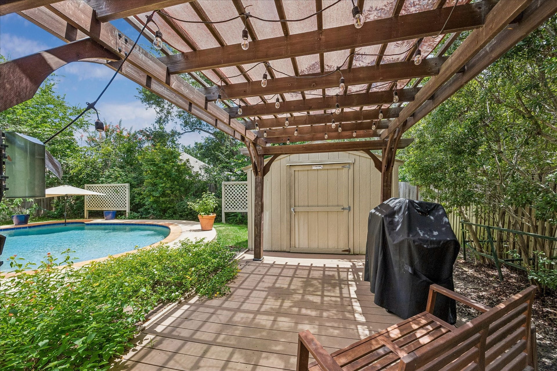 Charming pergola-covered patio creates the perfect setting for outdoor dining, weekend barbecues, and relaxing evenings under the string lights.