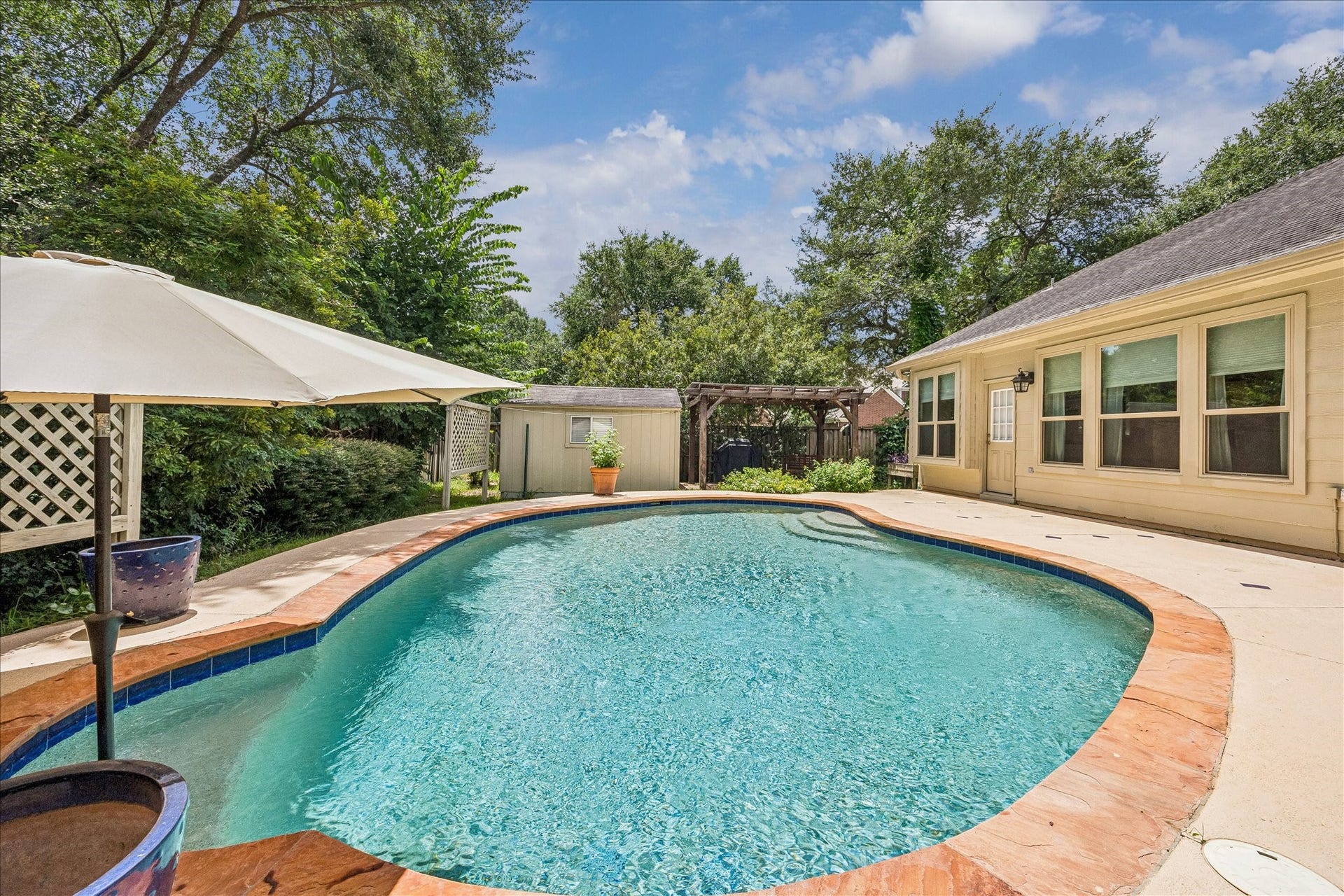 Inviting covered entry highlighted by charming brick detailing, established landscaping, and a welcoming front door.