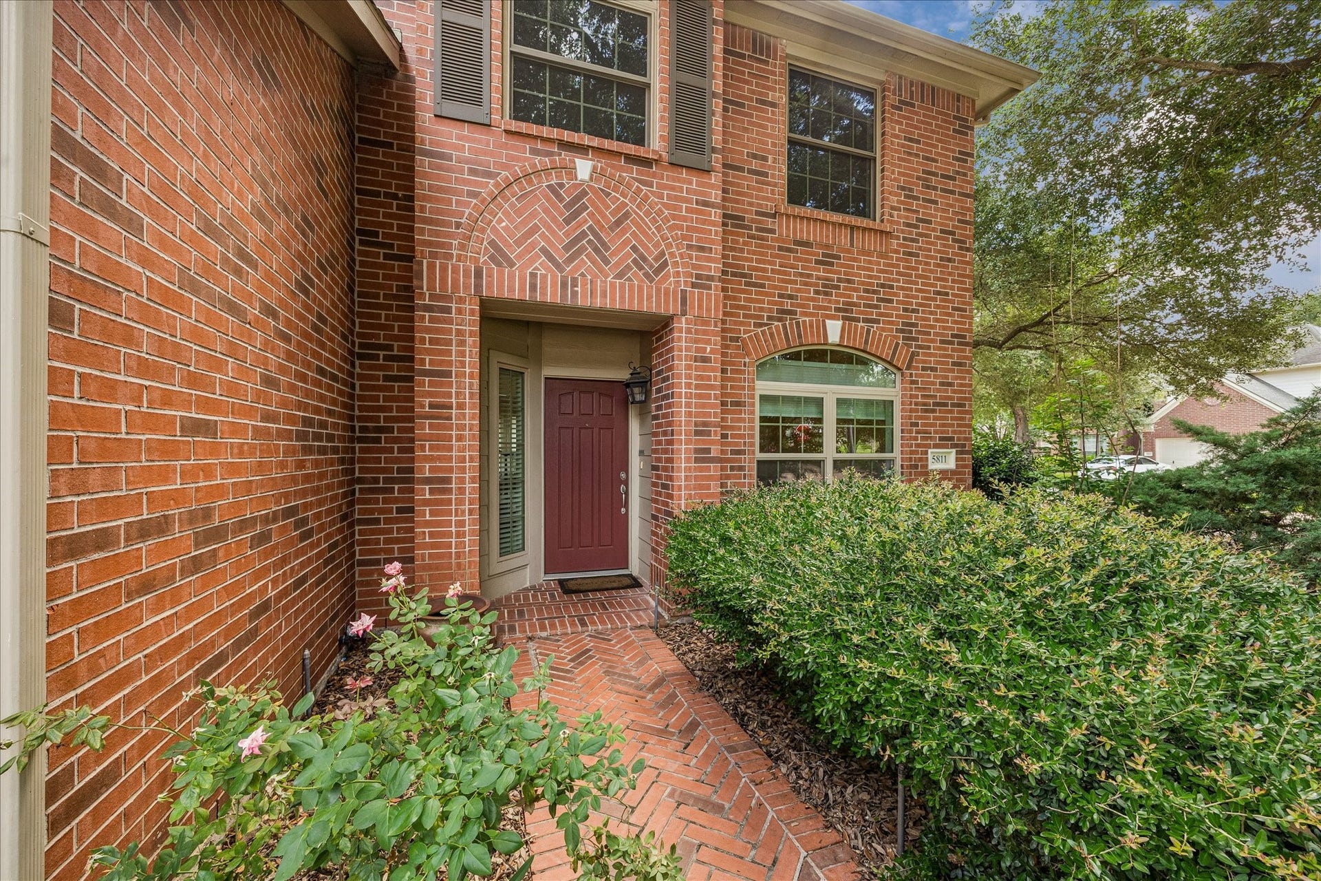 Light-filled family room with soaring ceilings, a cozy fireplace, and large windows overlooking the back pool.