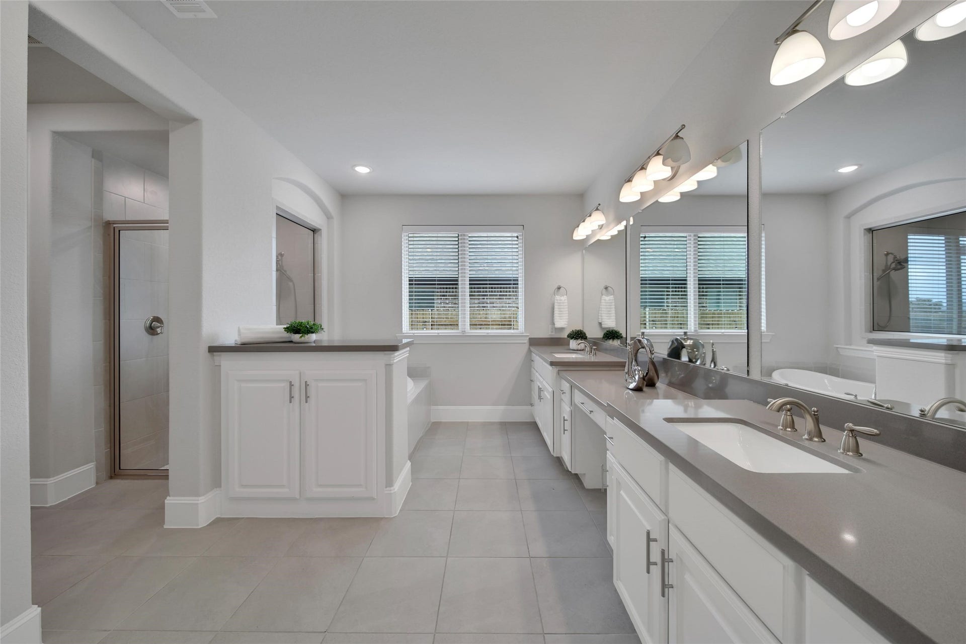 23935 Birchwood Lake Lane, Katy, TX 77493 Natural materials and neutral colors add suble elegance to the primary bathroom.The bathroom features dual sinks, a soaking tub, a separate shower, and ample storage for personal items and linens.