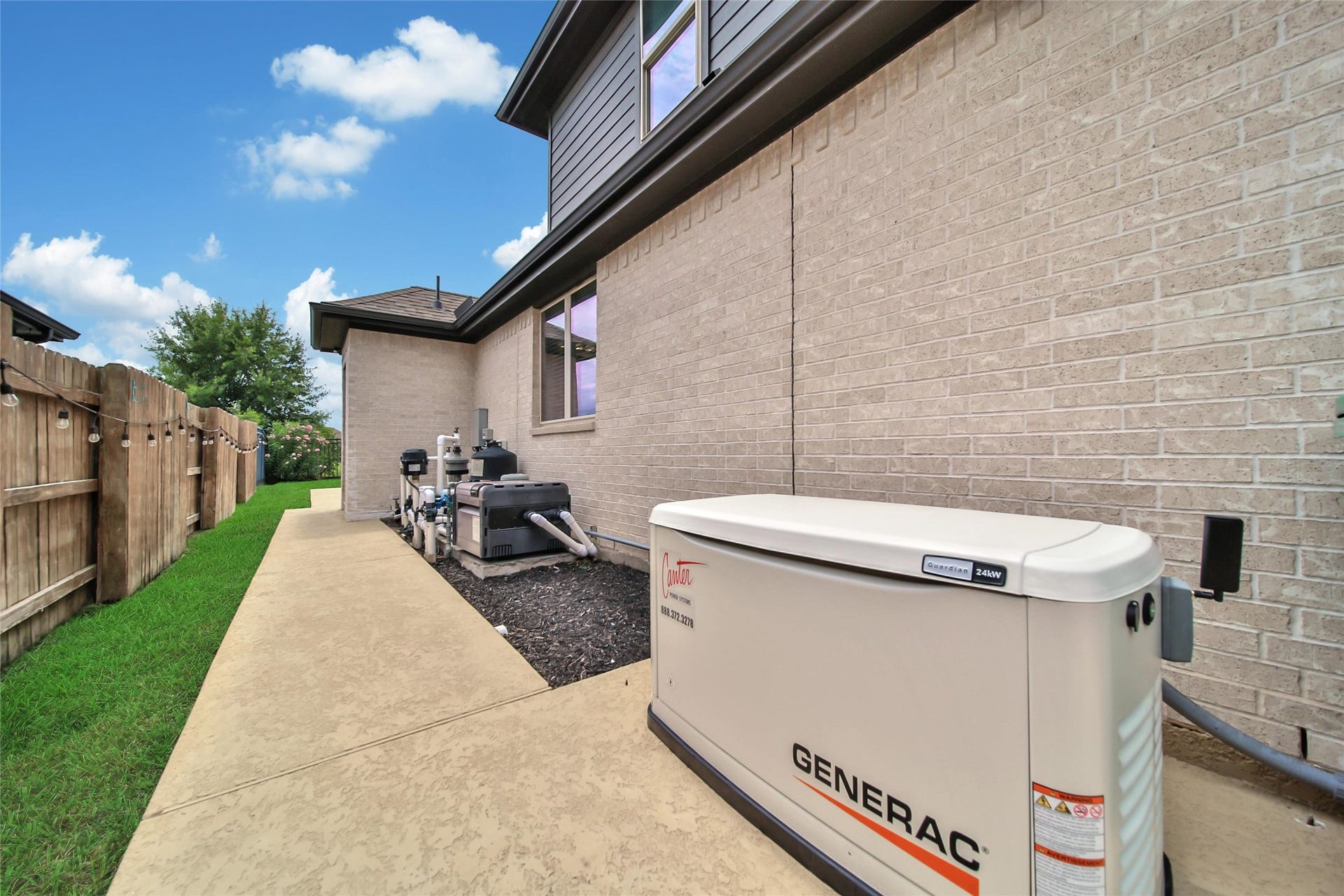 23935 Birchwood Lake Lane, Katy, TX 77493 A whole-home Generac generator provides peace of mind by keeping your lights, appliances, and essential systems running smoothly during power outages. A sidewalk and concrete slab inside the gate provide a convenient spot to store trash cans neatly out of sight.