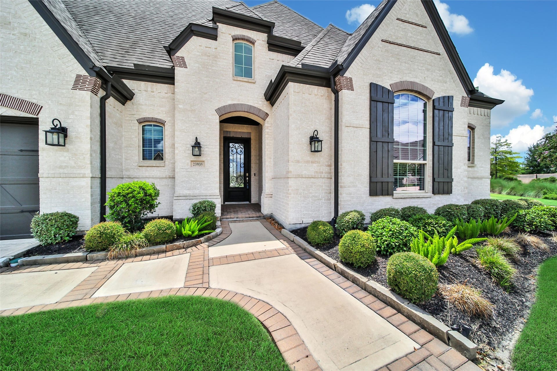 23935 Birchwood Lake Lane, Katy, TX 77493 A timeless brick exterior and manicured yard create grand curb appeal, welcoming guests with elegance.