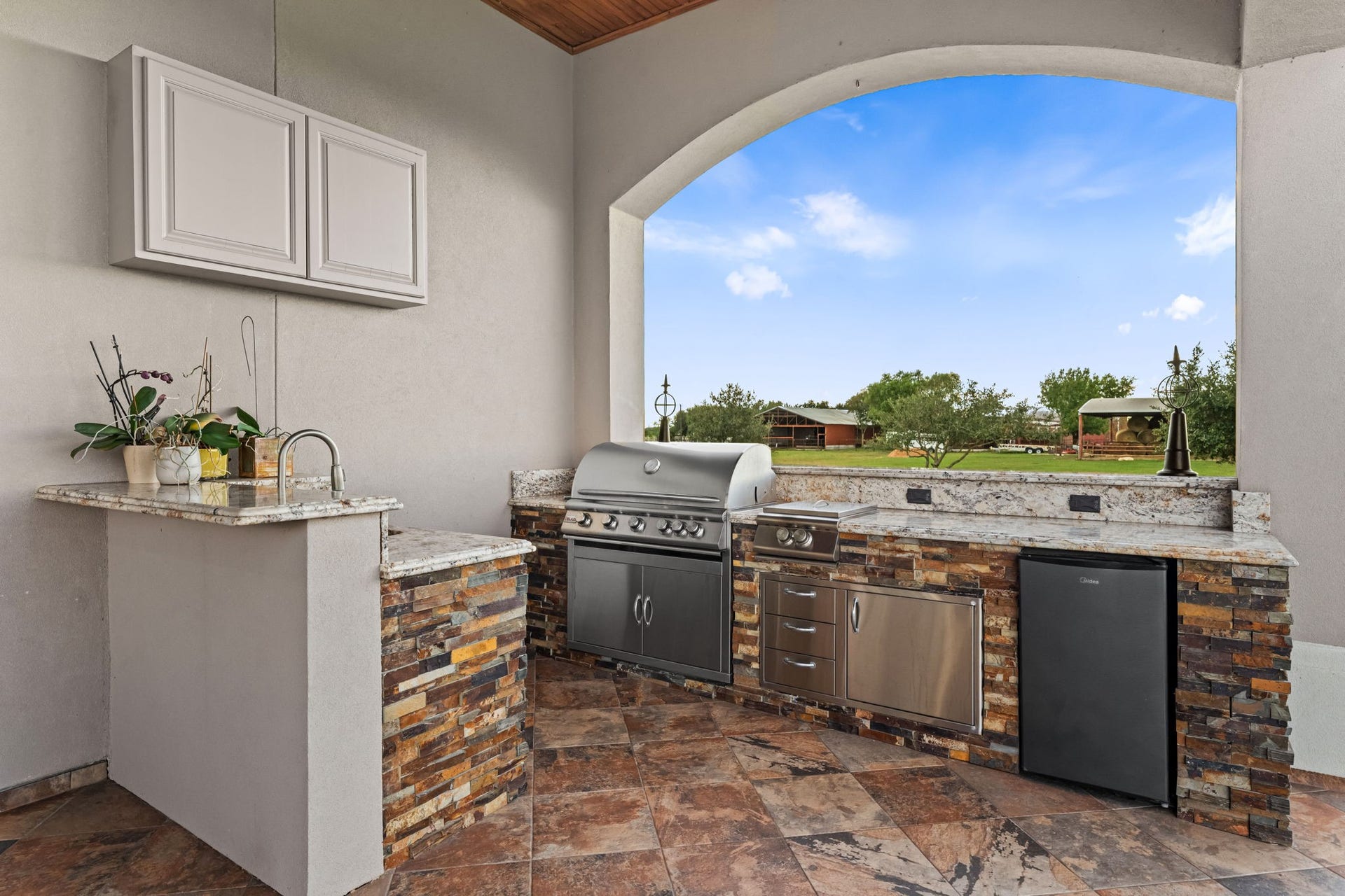 8145 Fm-1462, Rosharon, TX 77583 The outdoor kitchen features a range, sink, outdoor burner and refrigertor.