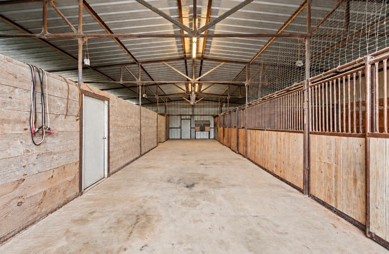 8145 Fm-1462, Rosharon, TX 77583 The well-equipped barn is 100 X 40 with four fully concreted stalls with washouts, a storage room and tack room. The back 40-feet of the barn is dirt floored and used for storage with a garage door opening. It can be concreted floored if needed.