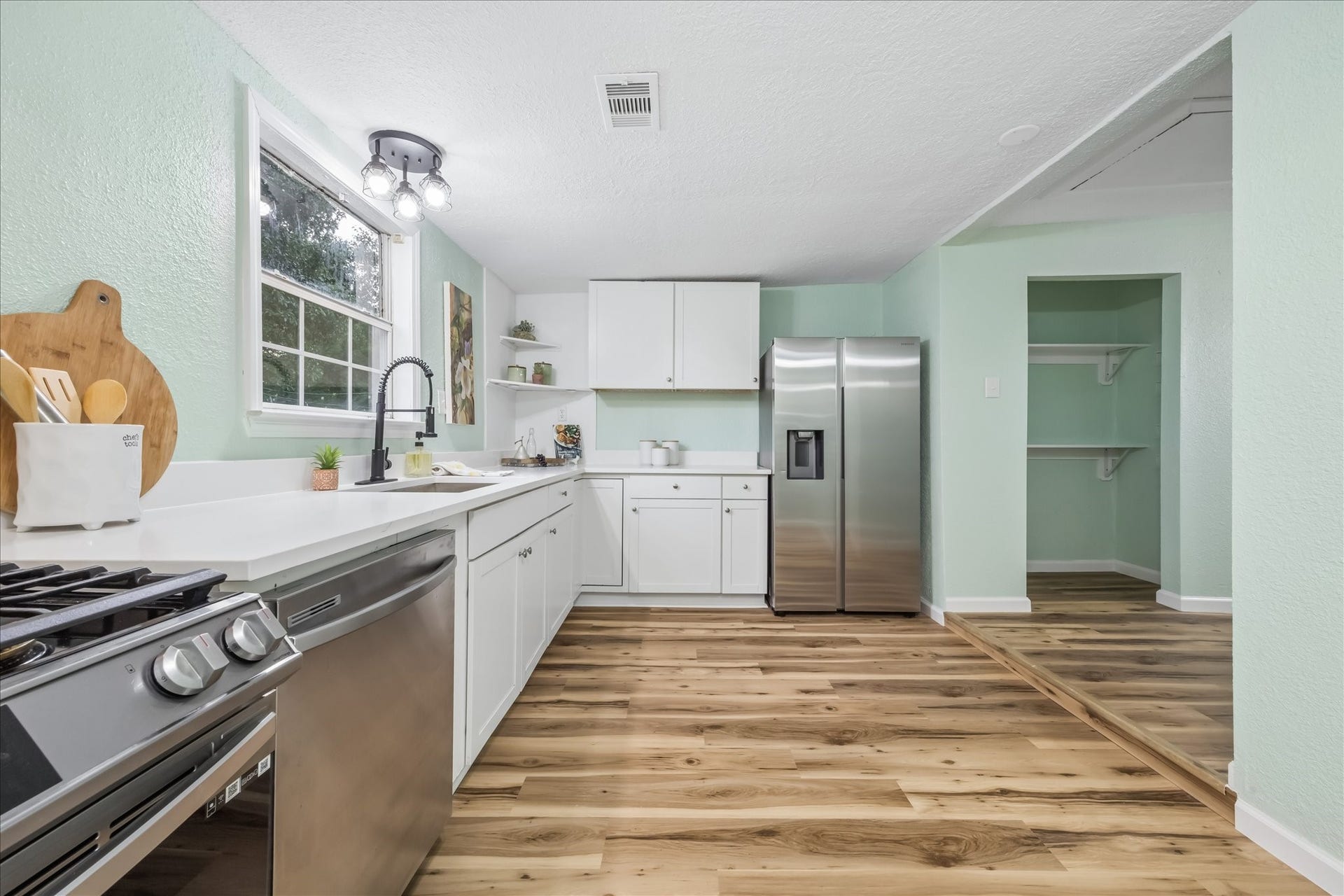 5122 Avenue L, Santa Fe, TX 77510 White cabinetry, gas cooking, and a spacious pantry.