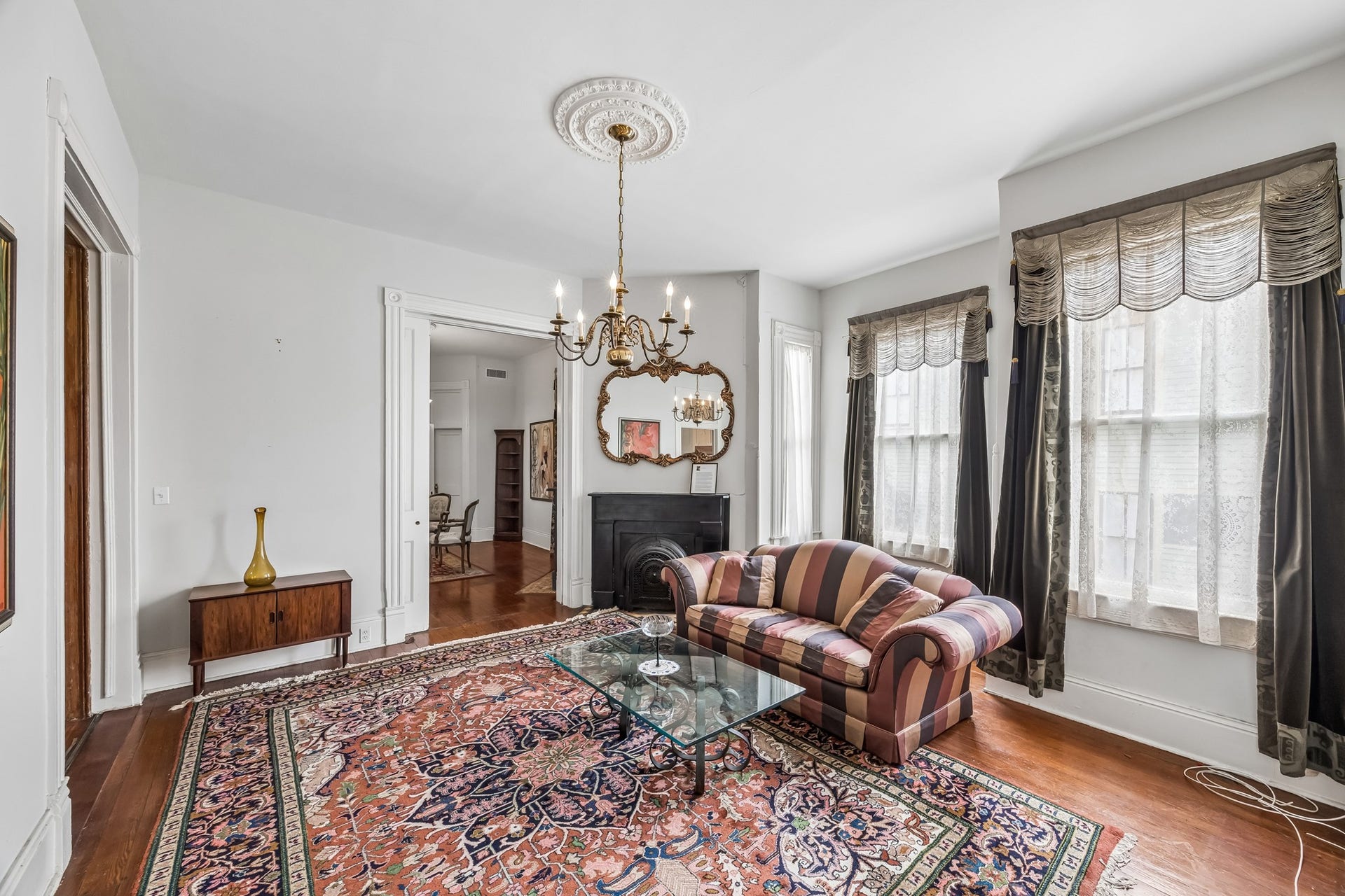 1818 Broadway Street, Galveston, TX 77550 The formal living room filled with natural light. All the celings are 12 feet high. Elegant modern brass chandelier that fits this period home.