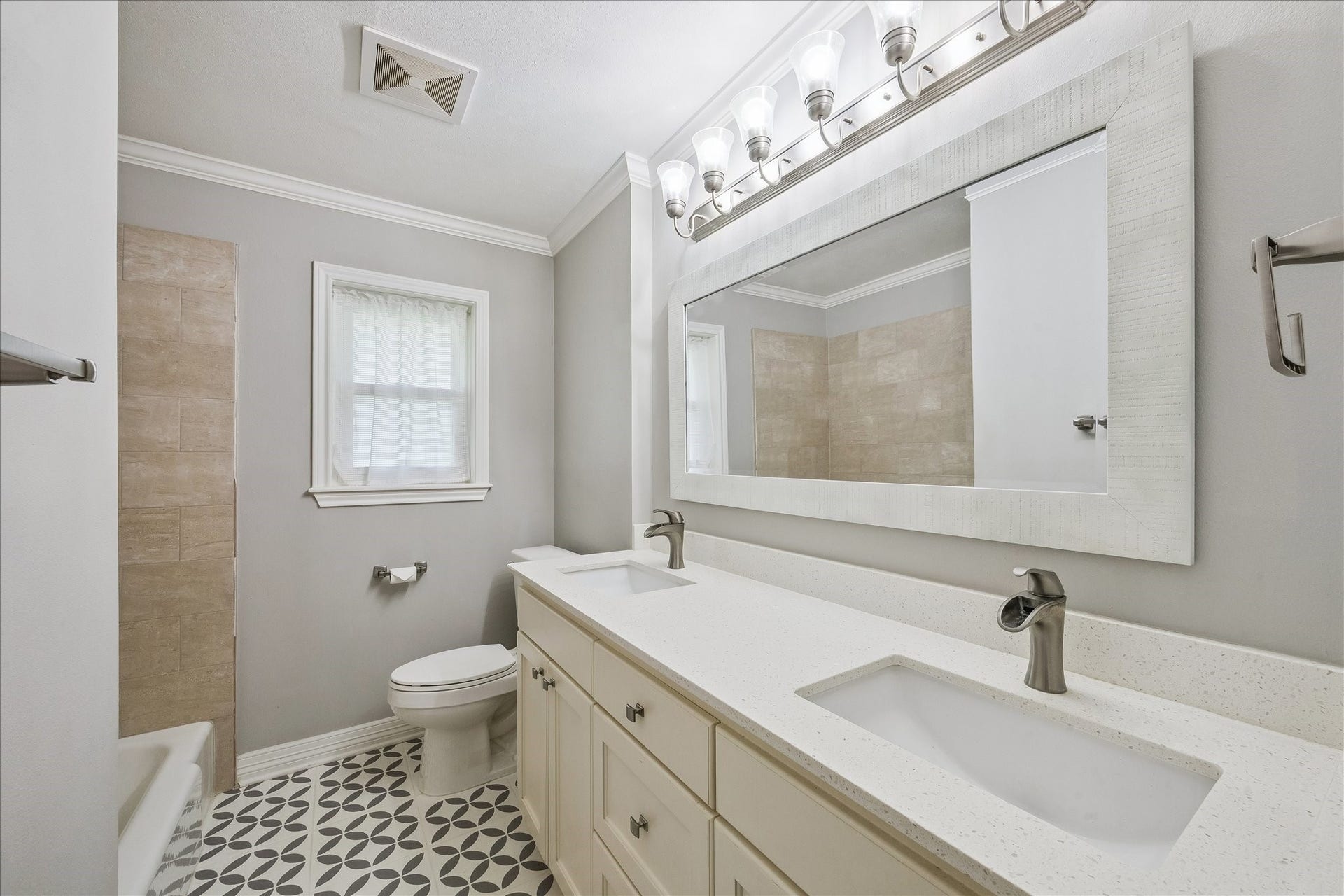 12511 Britt Road, Pearland, TX 77584 Hall bath highlights include a quartz counter, double sinks, single-hole waterfall faucets and a tiled shower/tub area.