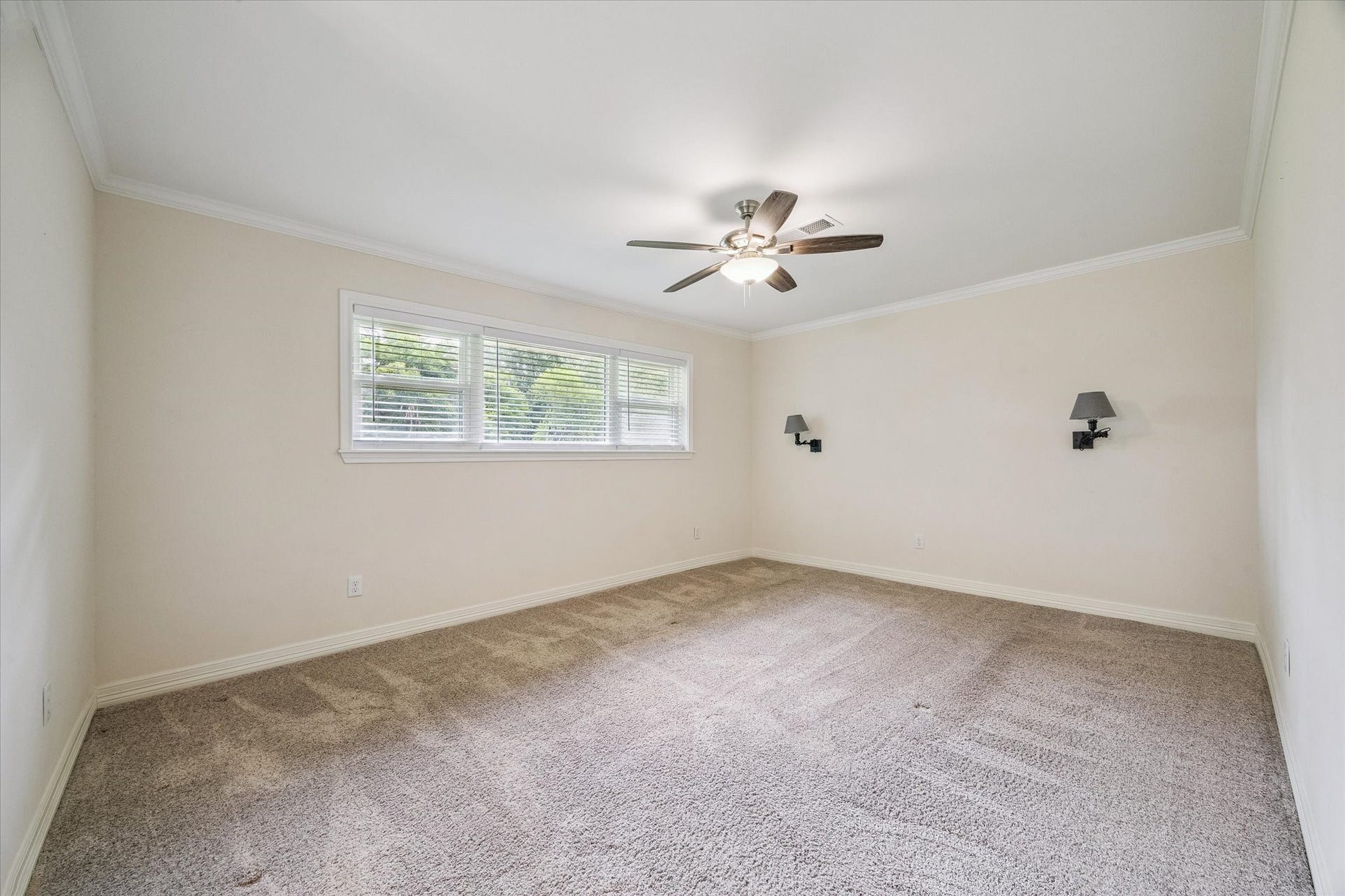 12511 Britt Road, Pearland, TX 77584 Spacious primary bedroom with crown molding, wall sconces and plush carpeting.