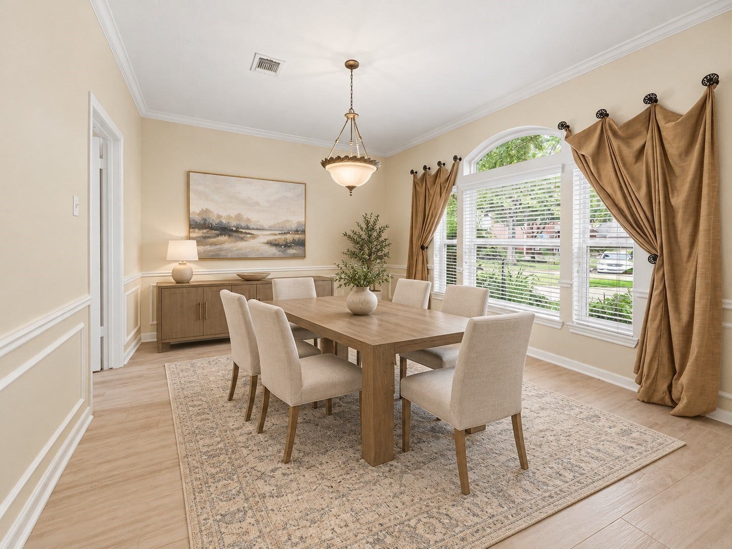 Formal dining room with large windows, beautiful tile floor, and wainscoting. *virtually staged