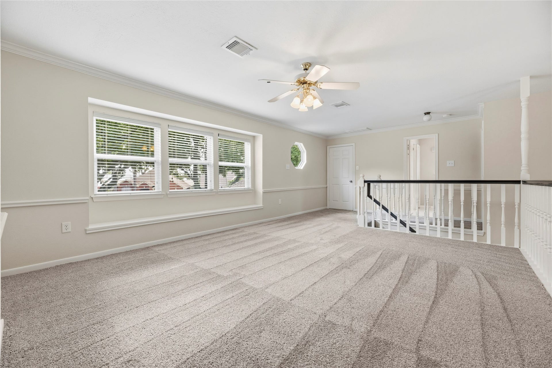 Large upstairs gameroom/flex area features plush carpeting and lots of natural light, creating a comfortable and inviting atmosphere.
