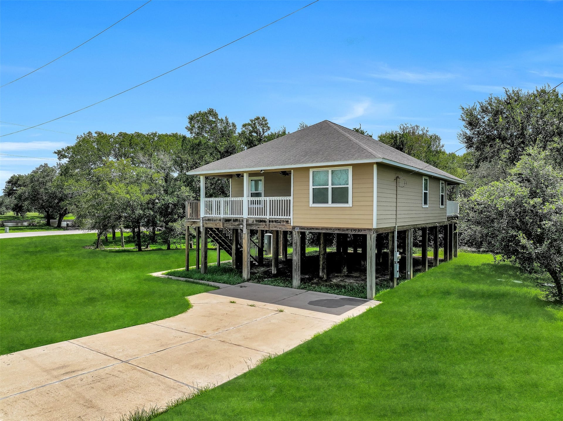 11930 Bastrop Beach Road, Angleton, TX 77515 Trade the ordinary for elevated living. Built on 10-foot pillars and tucked beneath mature shade trees on more than an acre, this custom home offers peace of mind, exceptional privacy, and a relaxed waterfront lifestyle just moments from Bastrop Bayou.
