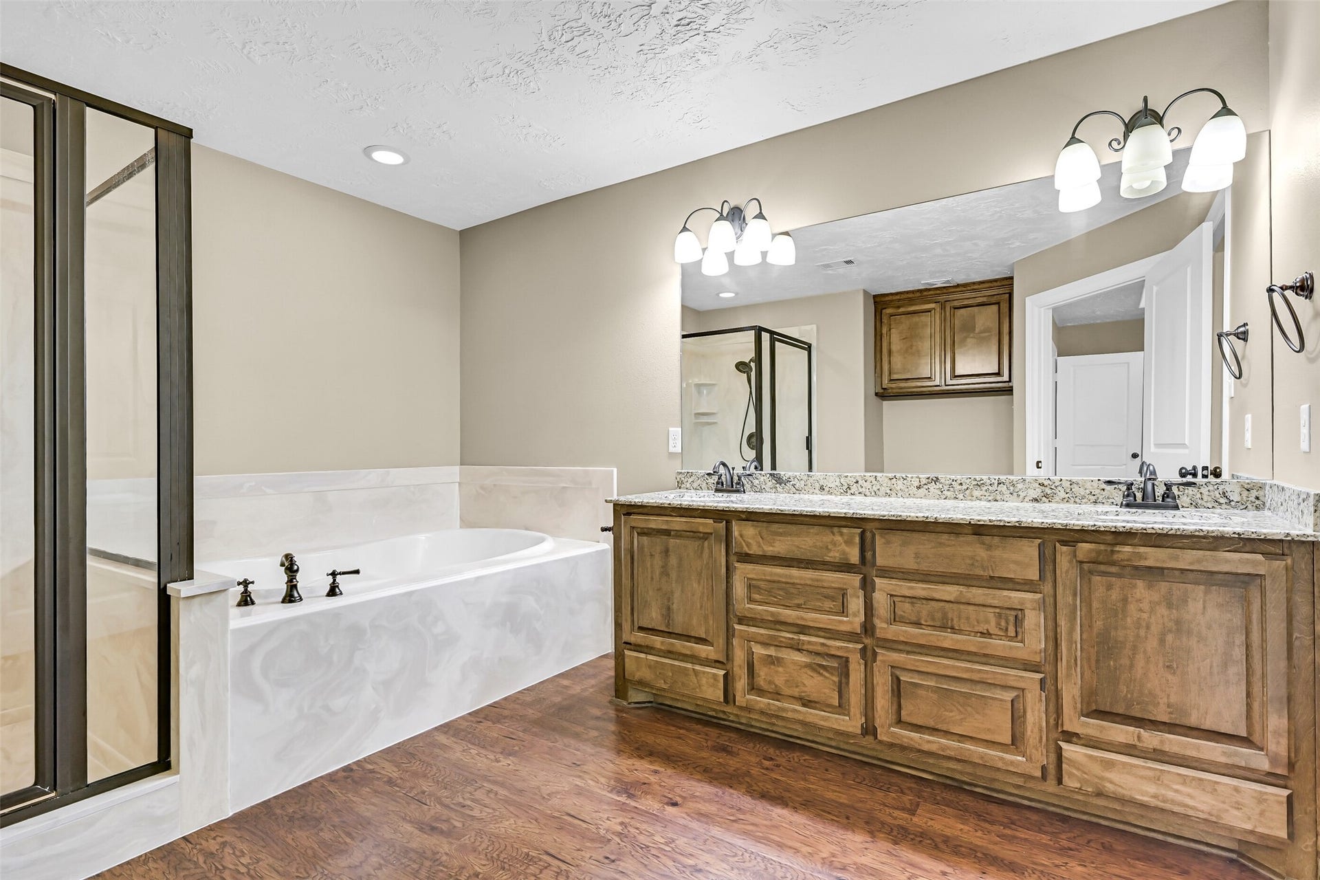 11930 Bastrop Beach Road, Angleton, TX 77515 The spacious ensuite bath showcases dual granite vanities with custom cabinetry, a relaxing soaking tub, separate shower, and plenty of room to begin and end each day in comfort.