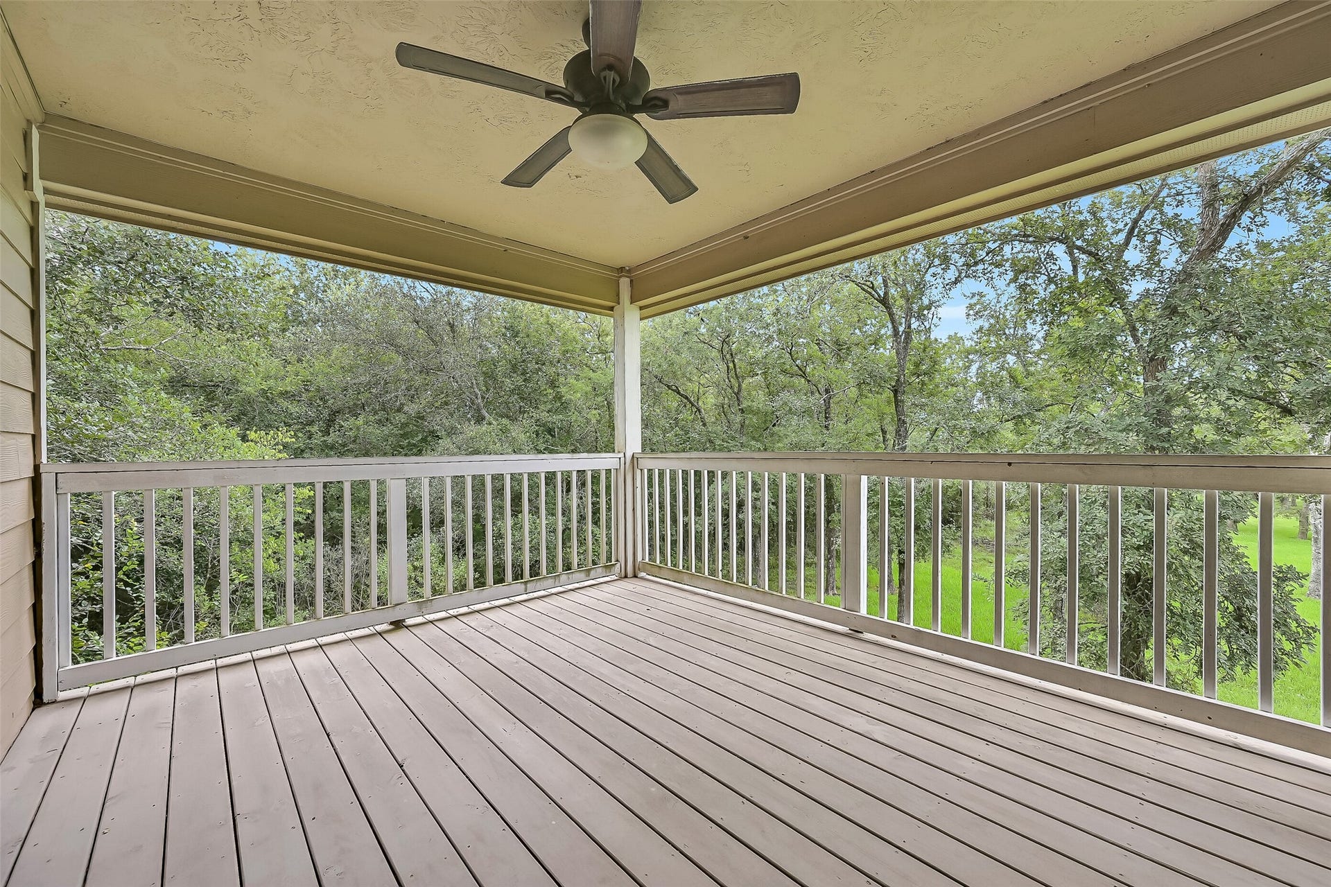 11930 Bastrop Beach Road, Angleton, TX 77515 Your favorite room may just be outside. This spacious covered porch overlooks the wooded surroundings, offering a peaceful place to enjoy your morning coffee, listen to the birds, or unwind after a day on the bayou.