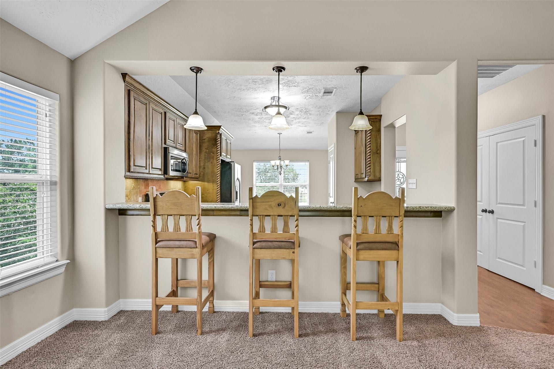 11930 Bastrop Beach Road, Angleton, TX 77515 The oversized bartop creates the perfect gathering spot for casual meals, morning coffee, or visiting with family and friends while staying connected to the open-concept kitchen. (Virtually Staged)
