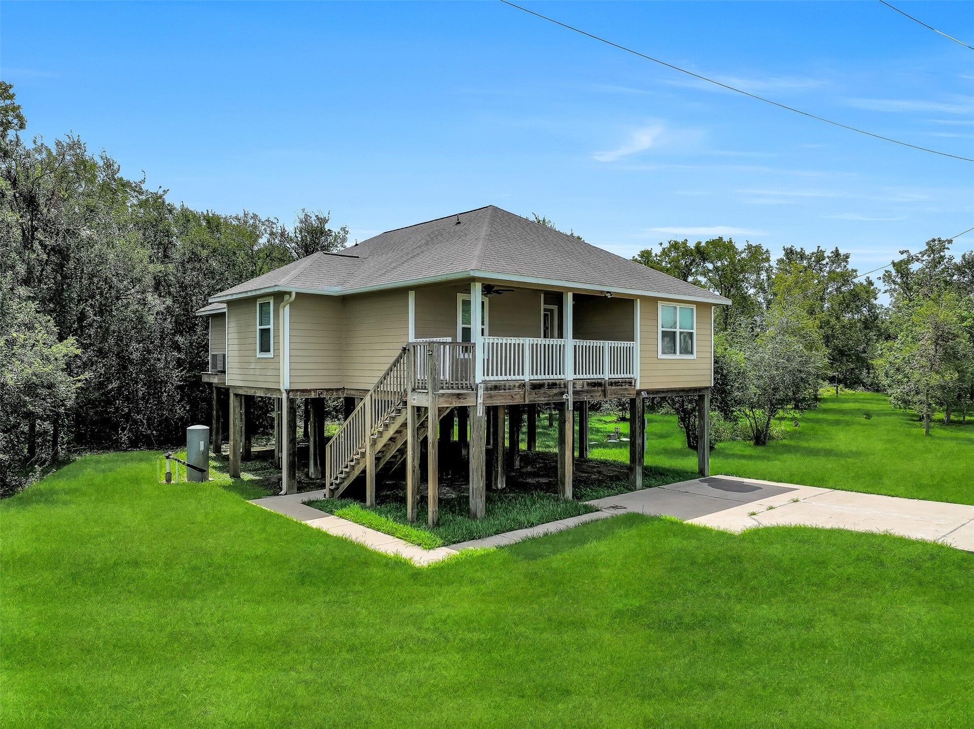 11930 Bastrop Beach Road, Angleton, TX 77515 Built on sturdy 10-foot pillars, this elevated custom home provides covered parking and storage below while offering added peace of mind. Surrounded by mature trees and open green space, the more-than-acre homesite delivers privacy in every direction.