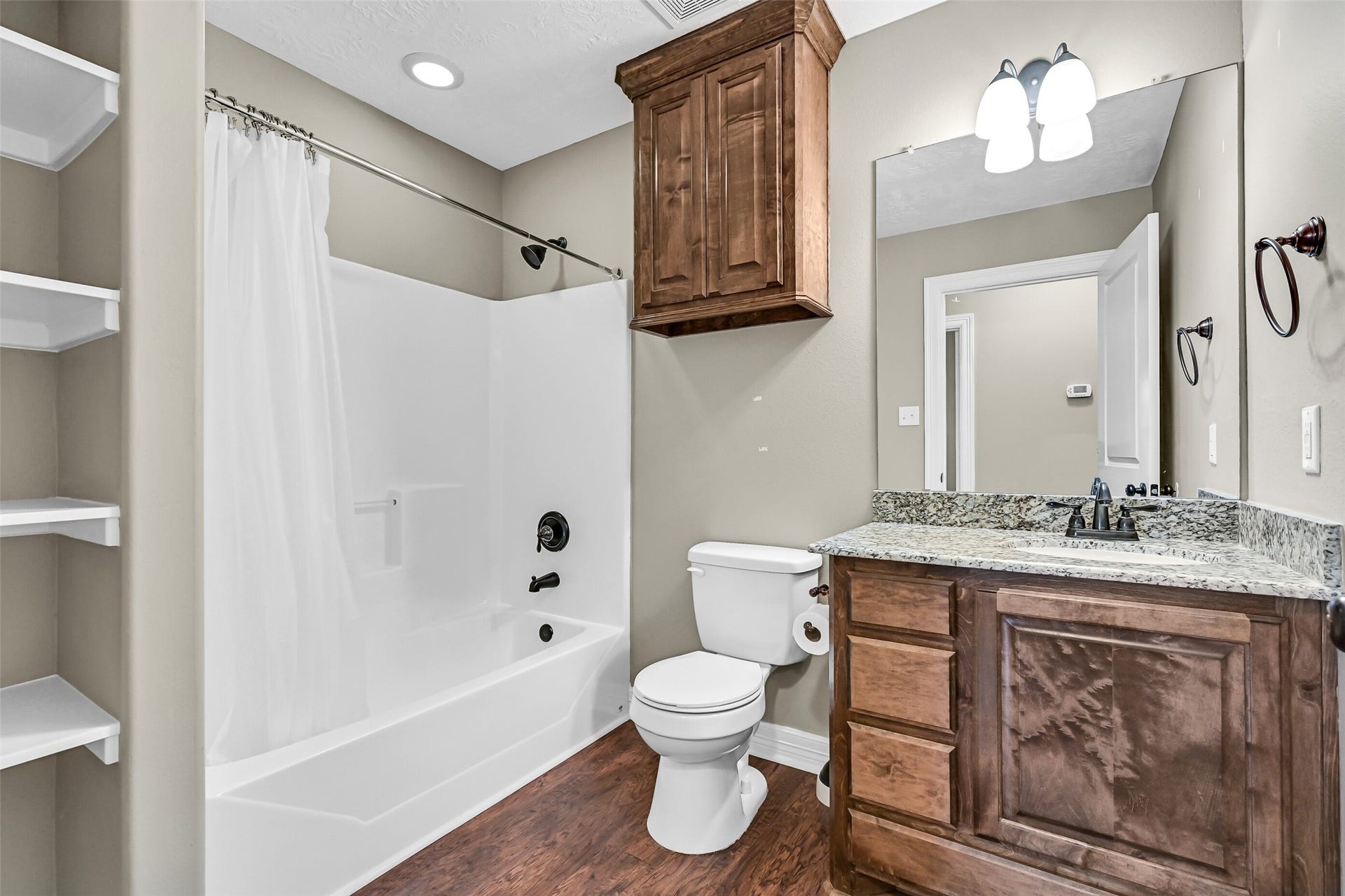 11930 Bastrop Beach Road, Angleton, TX 77515 Conveniently located between the secondary bedrooms, the hall bath features granite countertops, custom cabinetry, a tub/shower combination, and built-in linen shelving for added everyday storage.