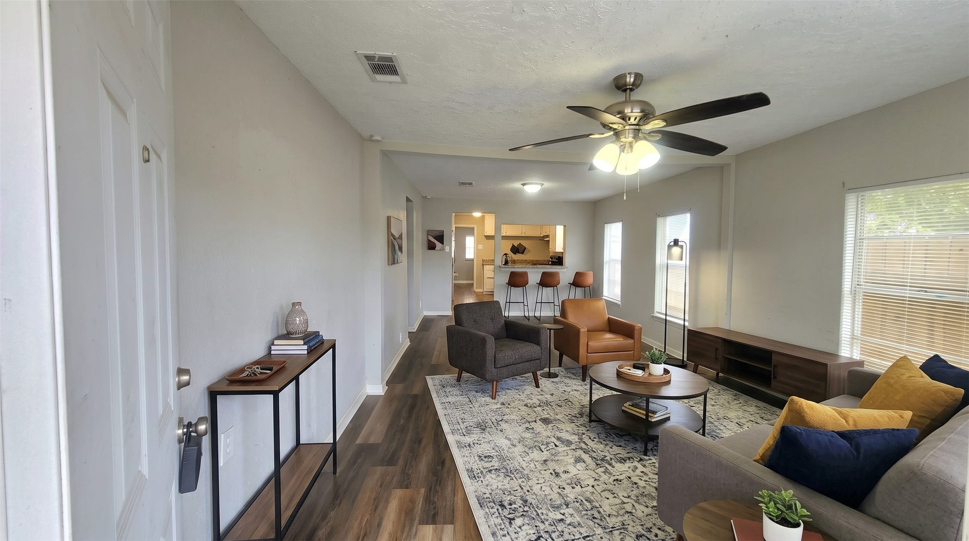 419 N Parrish Street, Angleton, TX 77515 Welcome to 419 N Parrish St in Angleton. The living room offers wood-look floors, a ceiling fan, and natural light from multiple windows. Virtually staged.