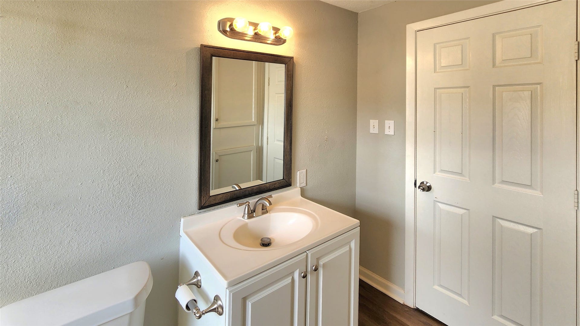 419 N Parrish Street, Angleton, TX 77515 Hallway bath vanity with framed mirror and Hollywood light fixture.